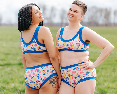 Two models smiling in a field wearing Thunderpants Bralette and underwear sets in Boot Scootin' print.