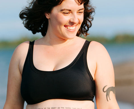 Model smiling wearing Swimwear Top in Plain Black.