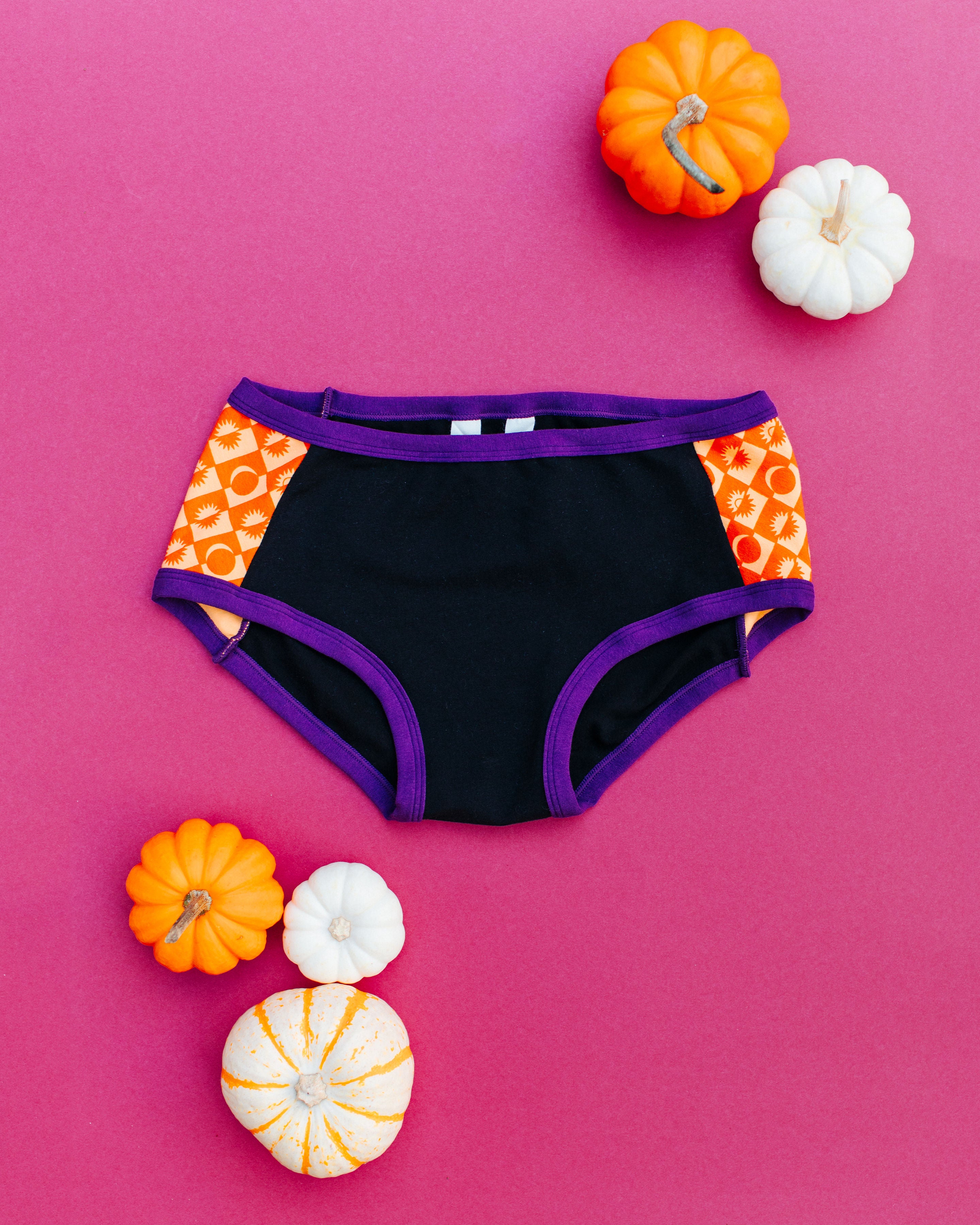 Flatlay of Thunderpants Hipster Panel Pants style underwear in Witch's Brew: Black with orange Autumn Equinox.