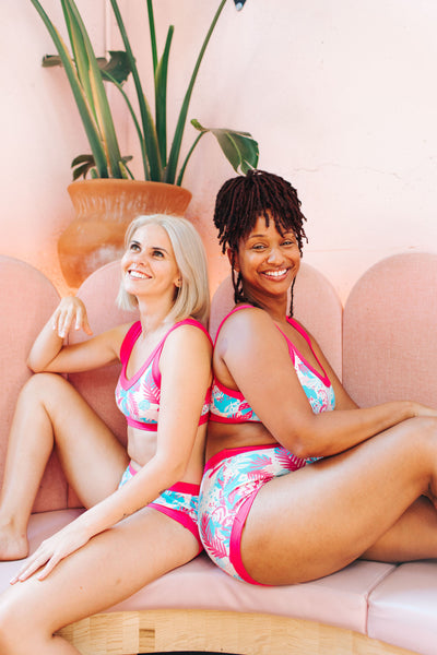 Two models smiling while wearing Thunderpants sets in Finding Flamingo print.