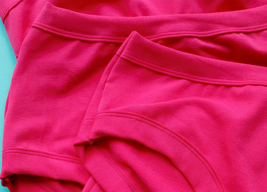 Flat lay close up of various Thunderpants underwear styles in a hot pink color.