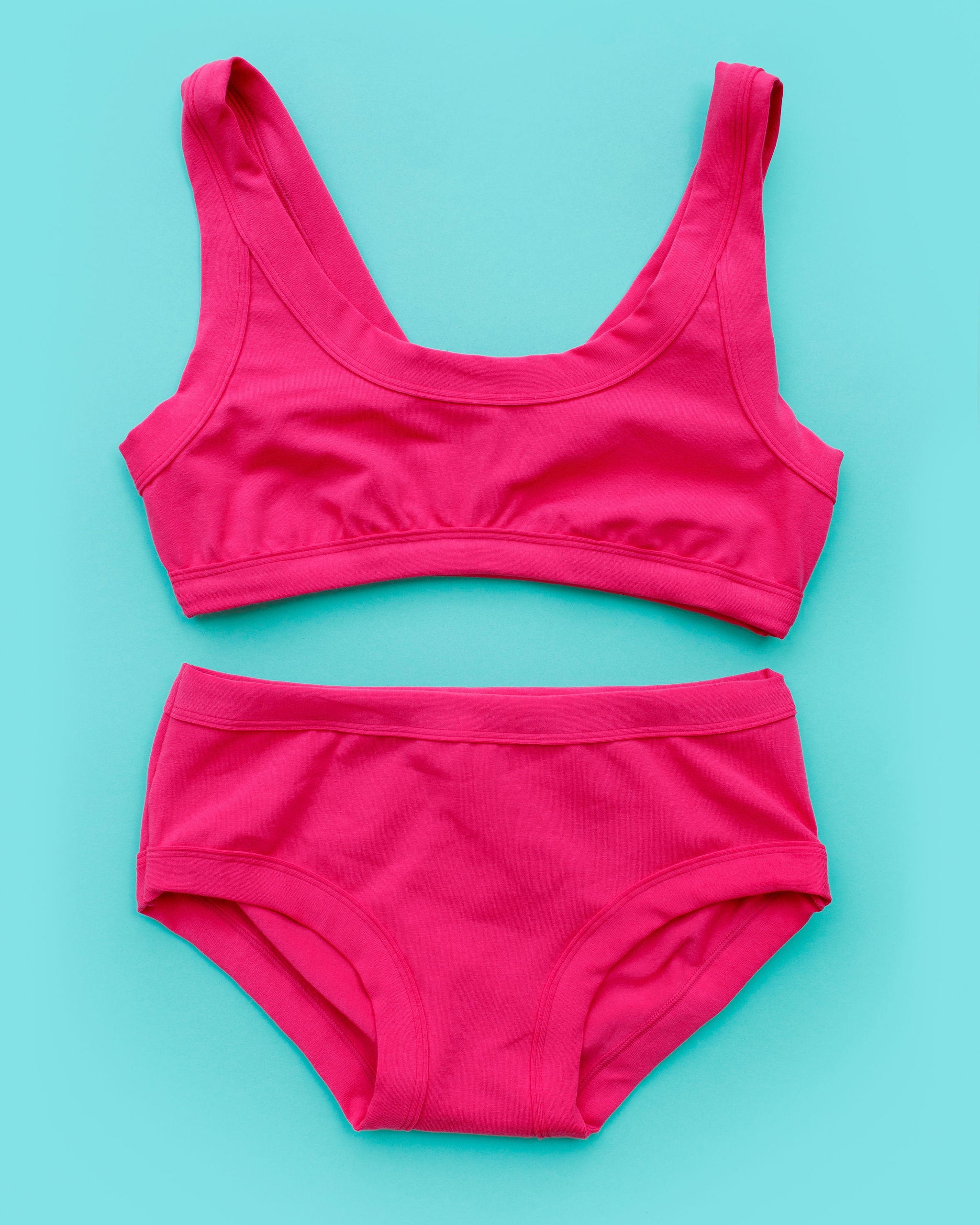 Flat lay of Thunderpants Bralette and Hipster style underwear in a hot pink color.