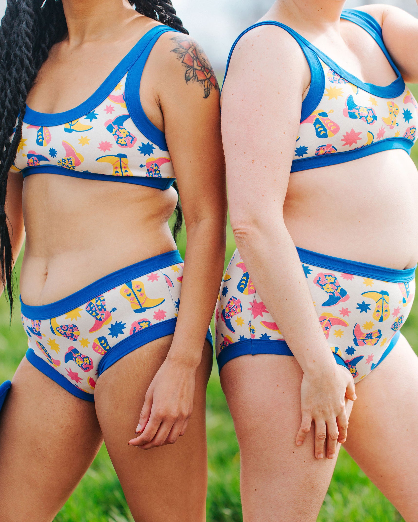 Close up of two models wearing Thunderpants sets in Boot Scootin' - fun boots in pink, yellow, and blue. 