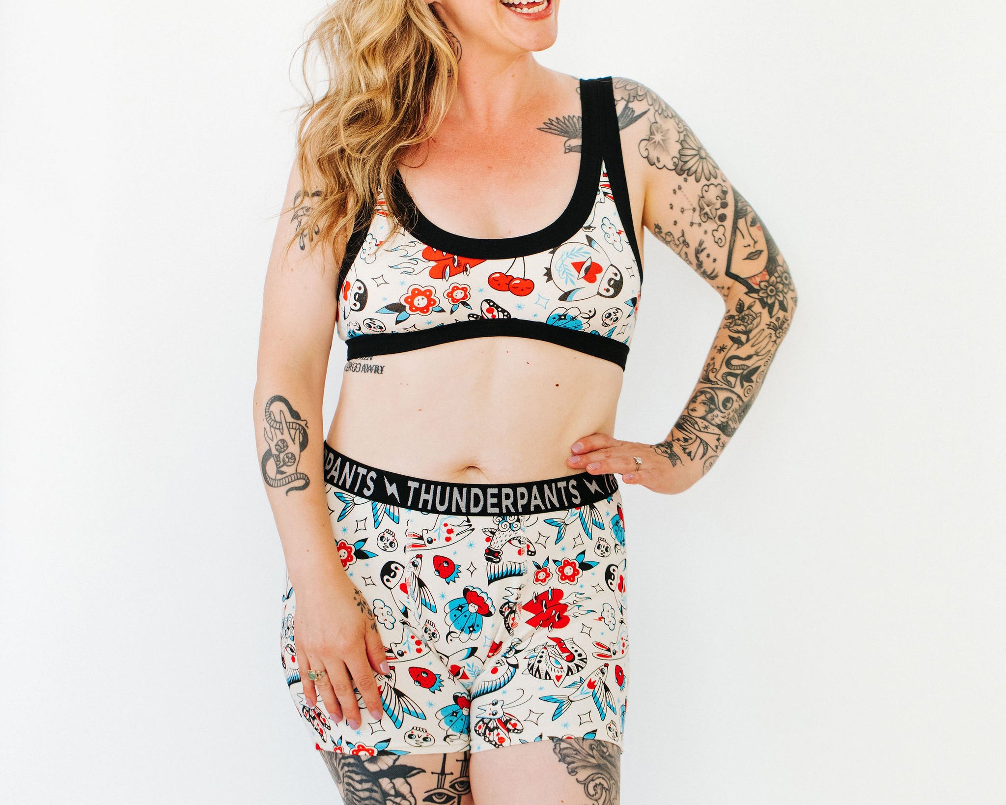 Model wearing Thunderpants Boxer Brief style underwear and Bralette in Inked Up - a tattoo pattern with black, red, and blue.