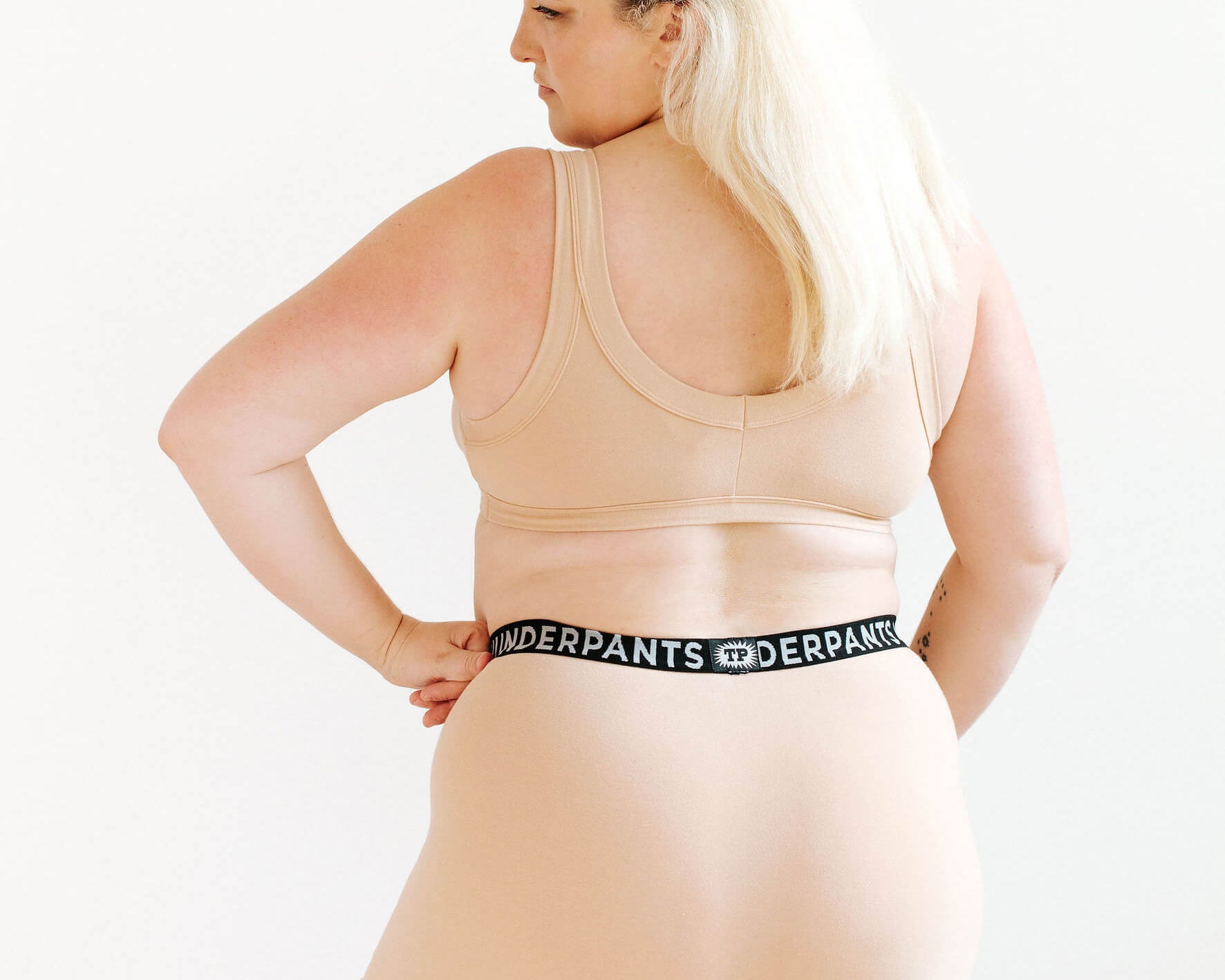 Model wearing Thunderpants Boxer Brief style underwear and Bralette in Pine Nut - lighter tan color.