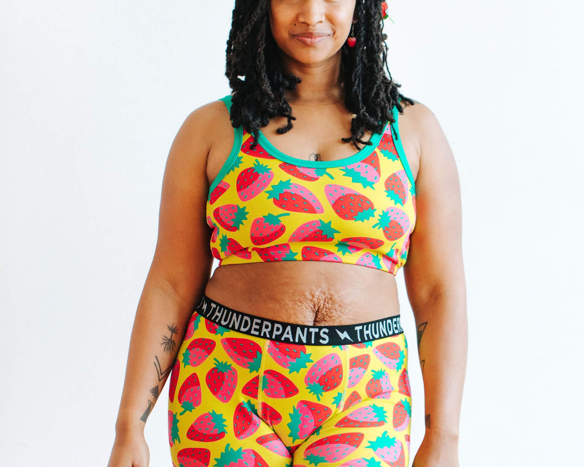 Model wearing Thunderpants Boxer Brief and Longline Bra in a Strawberry print - pink, red, and peacock green on chartreuse.