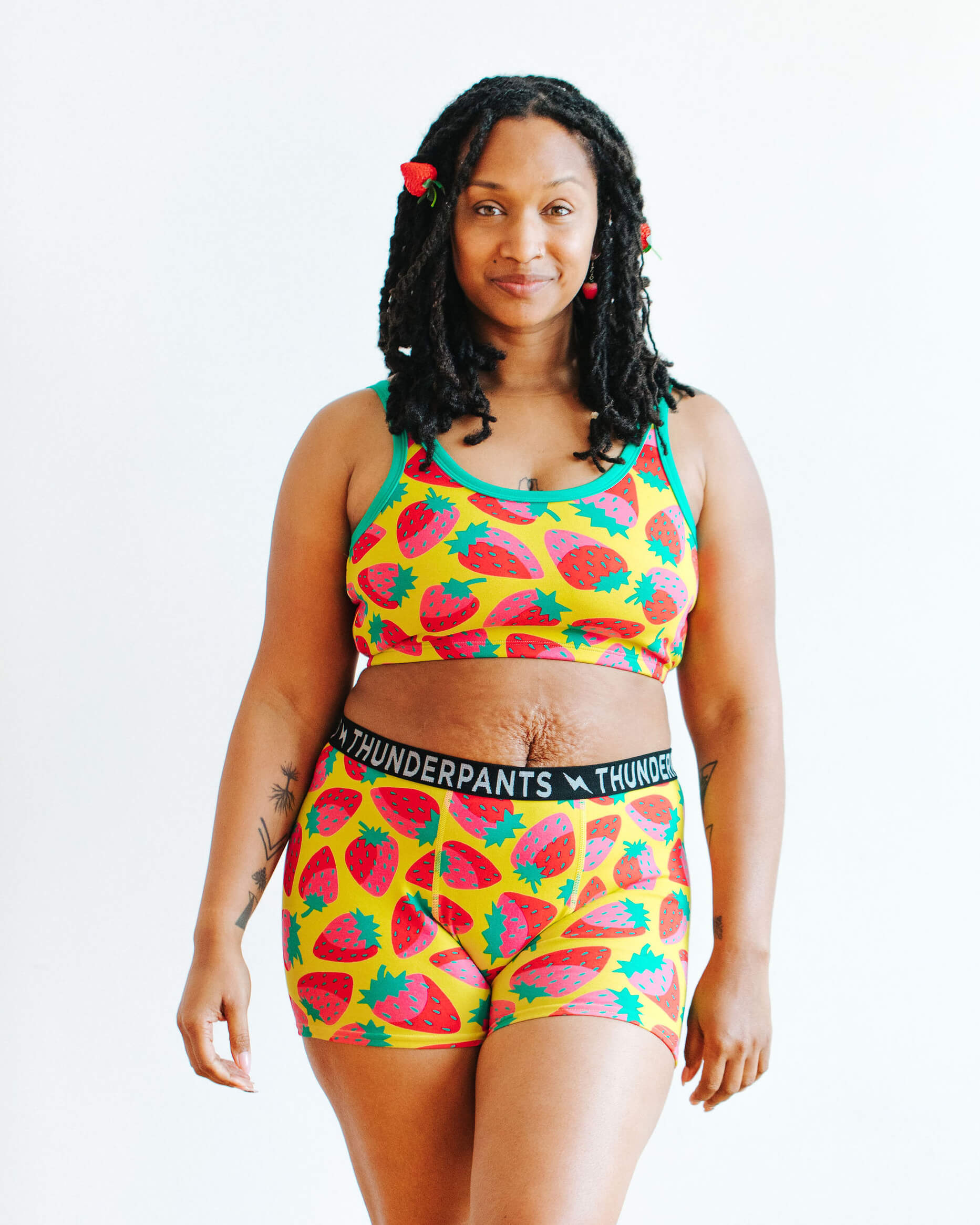Model wearing Thunderpants Boxer Brief and Longline Bra in a Strawberry print - pink, red, and peacock green on chartreuse.