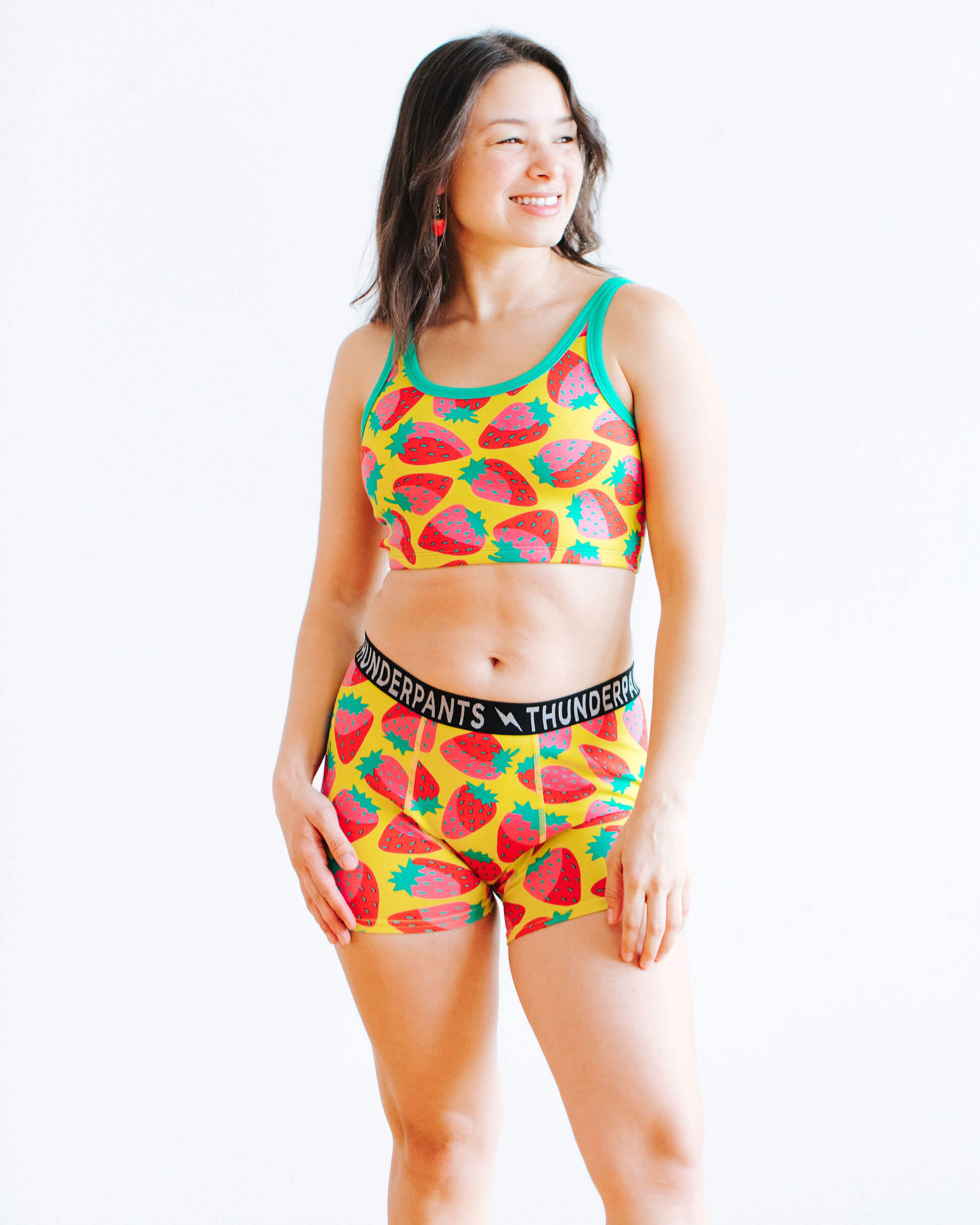 Model wearing Thunderpants Boxer Brief and Longline Bra in a Strawberry print - pink, red, and peacock green on chartreuse.