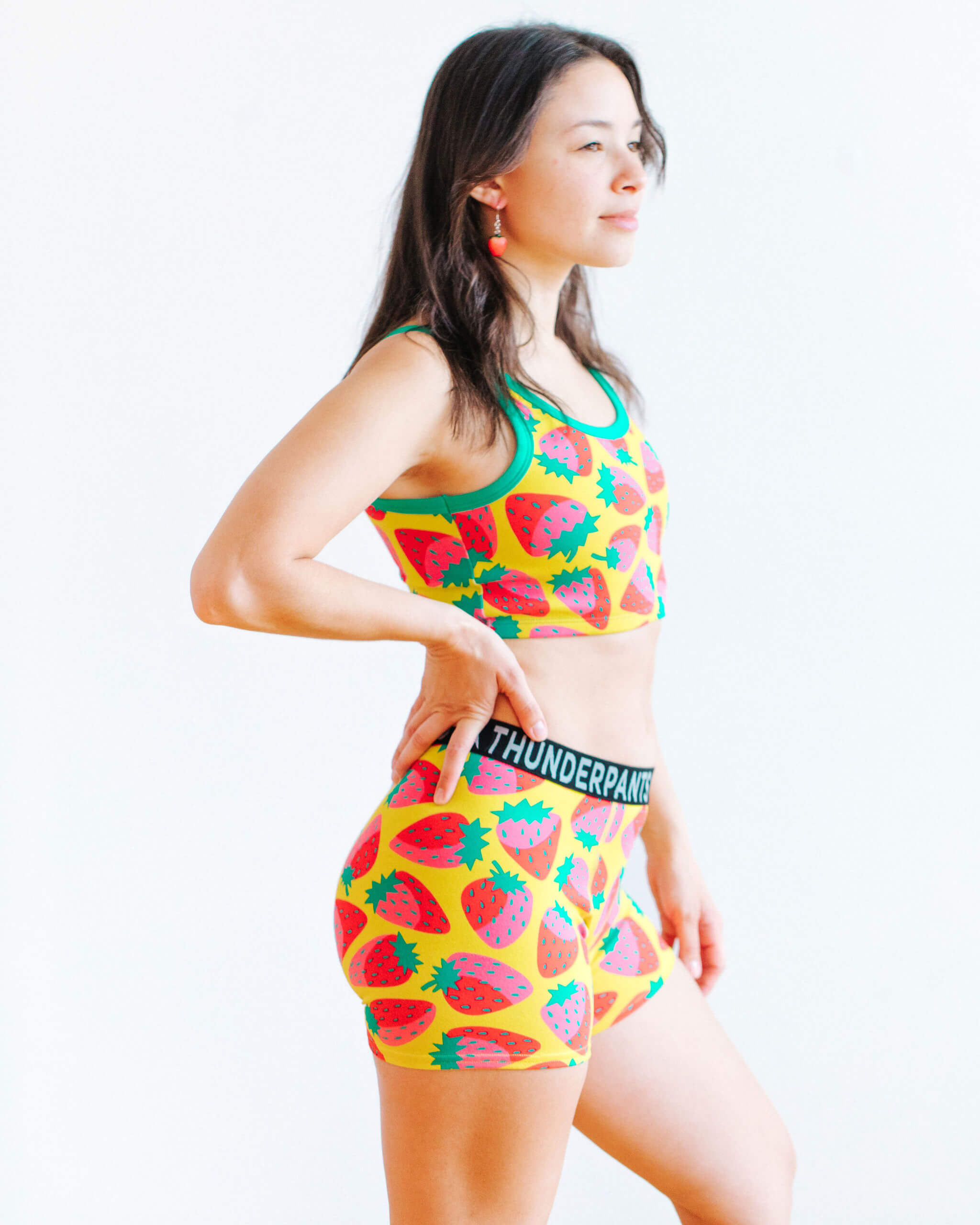 Model wearing Thunderpants Boxer Brief and Longline Bra in a Strawberry print - pink, red, and peacock green on chartreuse.