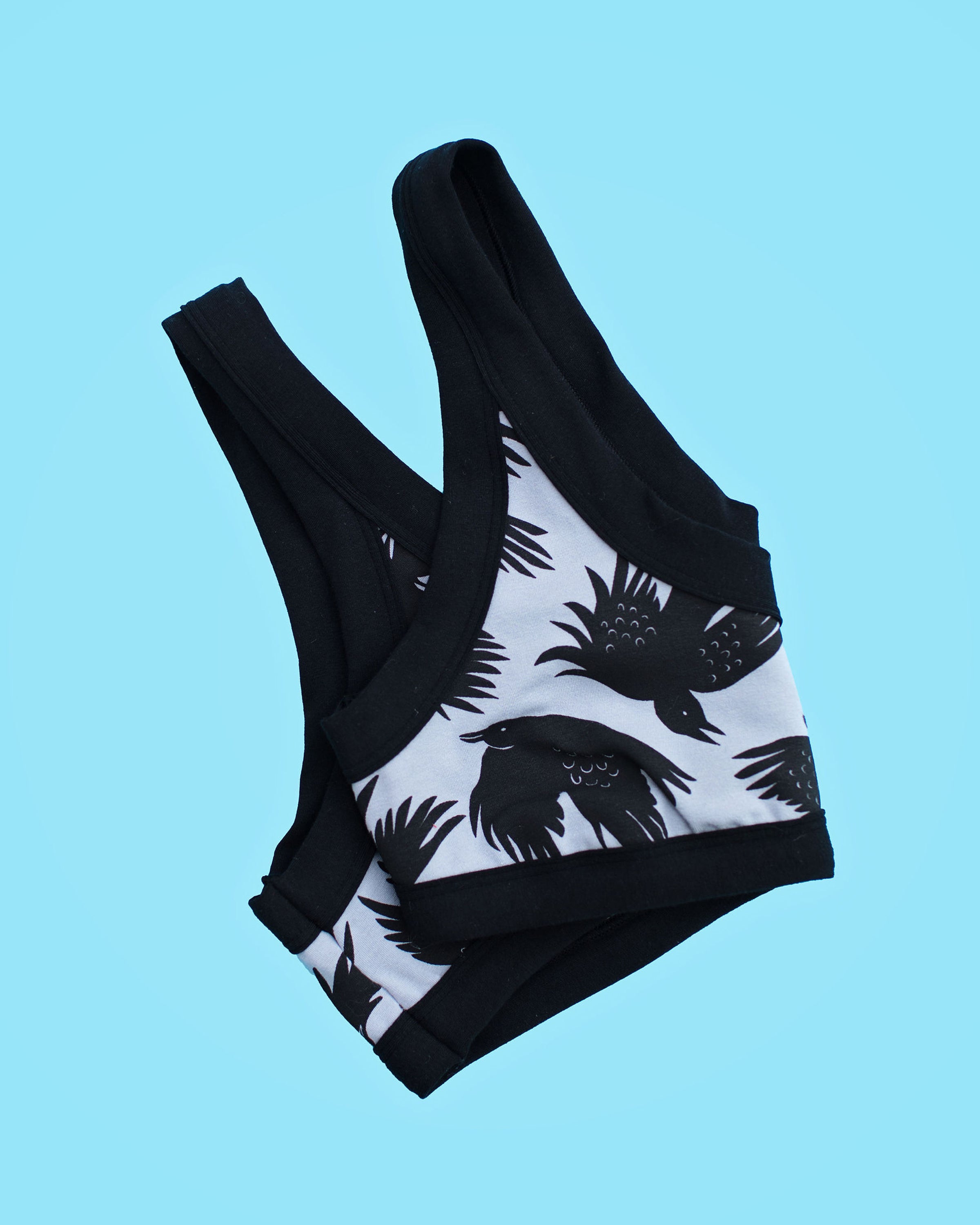 Flatlay of Thunderpants Bralette in So it Crows - black birds on grey.