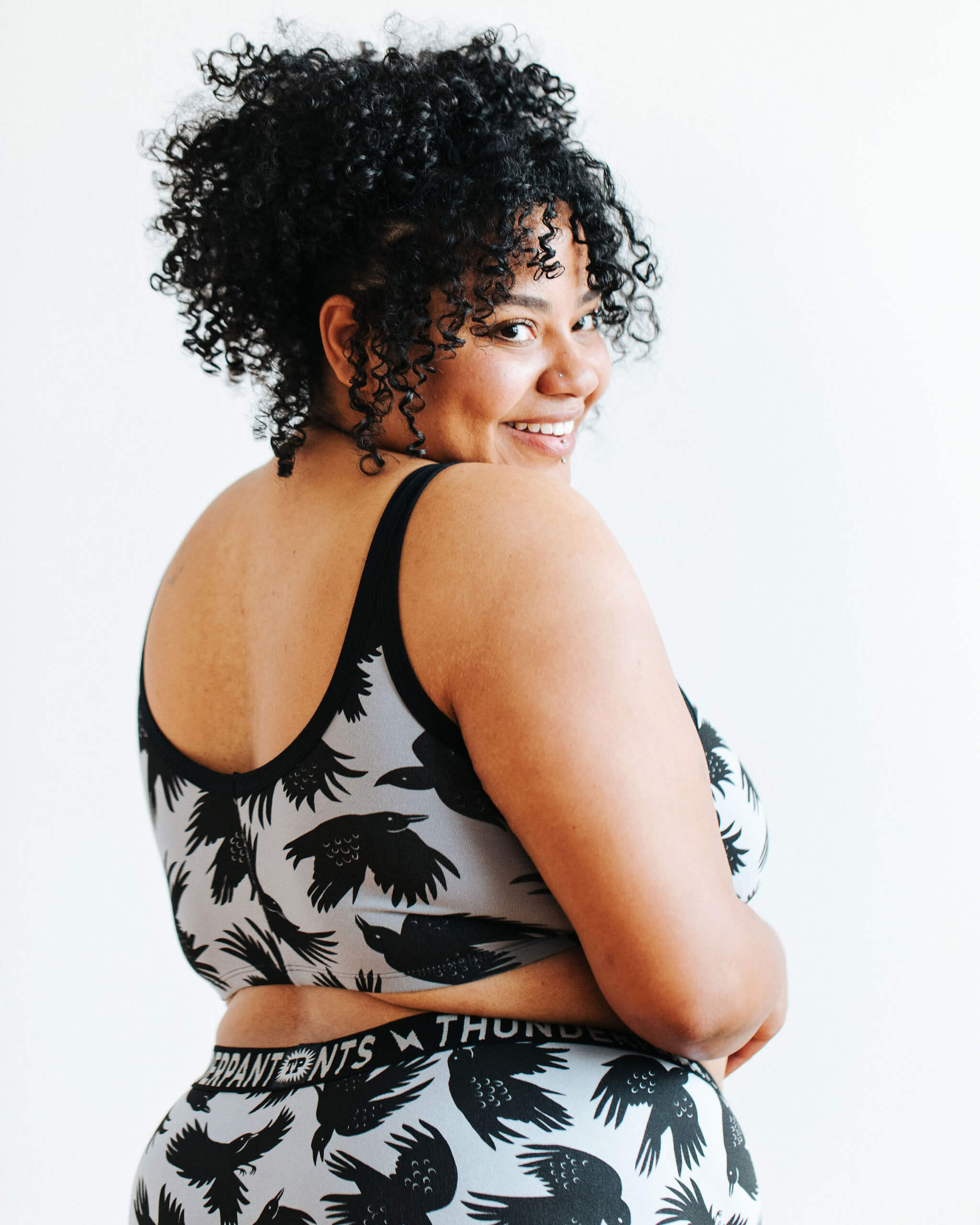 Model wearing Thunderpants Longline Bra in So it Crows - black crows on grey.