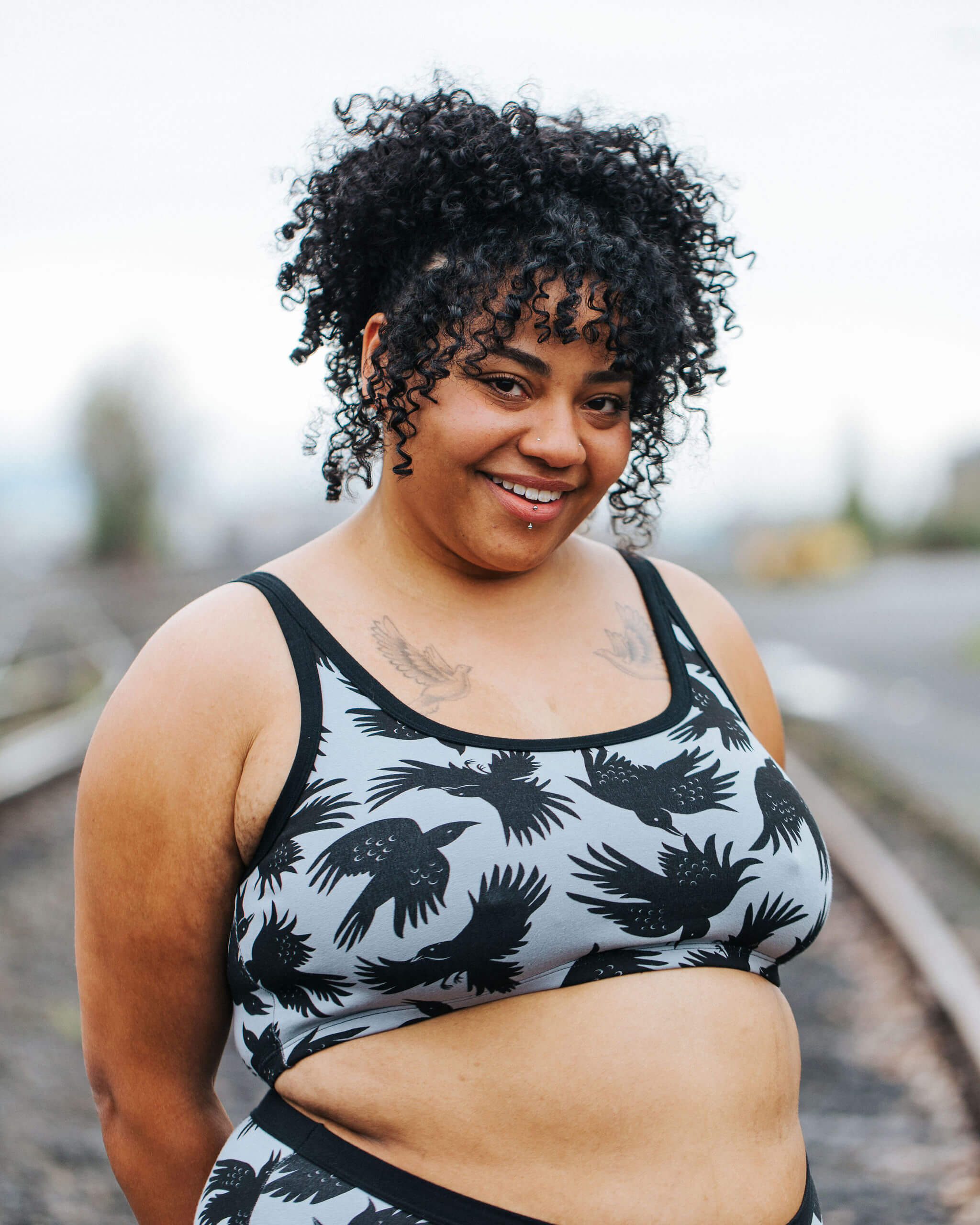 Model wearing Thunderpants Longline Bra in So it Crows - black crows on grey.