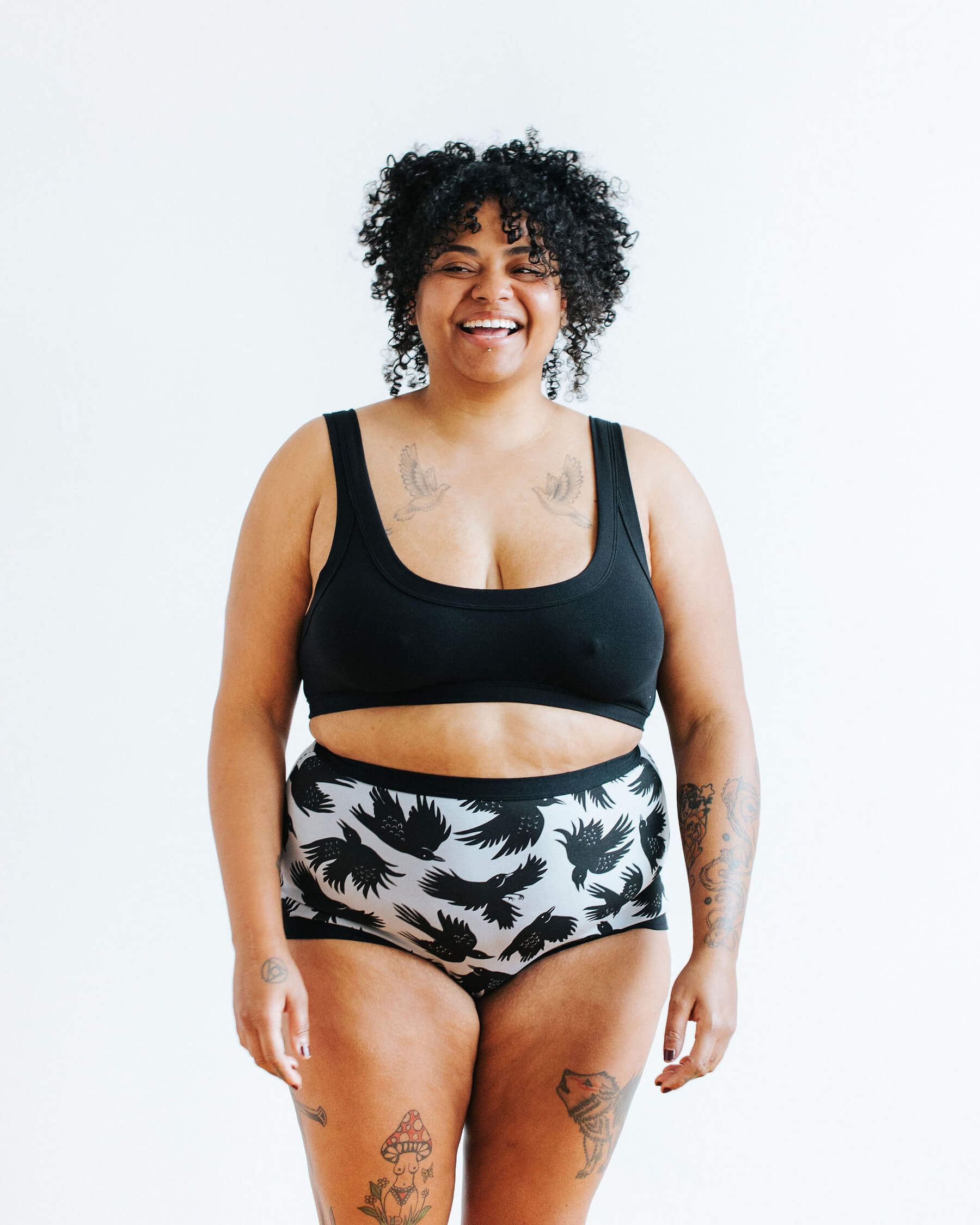 Model wearing Thunderpants Sky Rise style underwear in So it Crows - black crows in grey - and Plain Black Bralette.