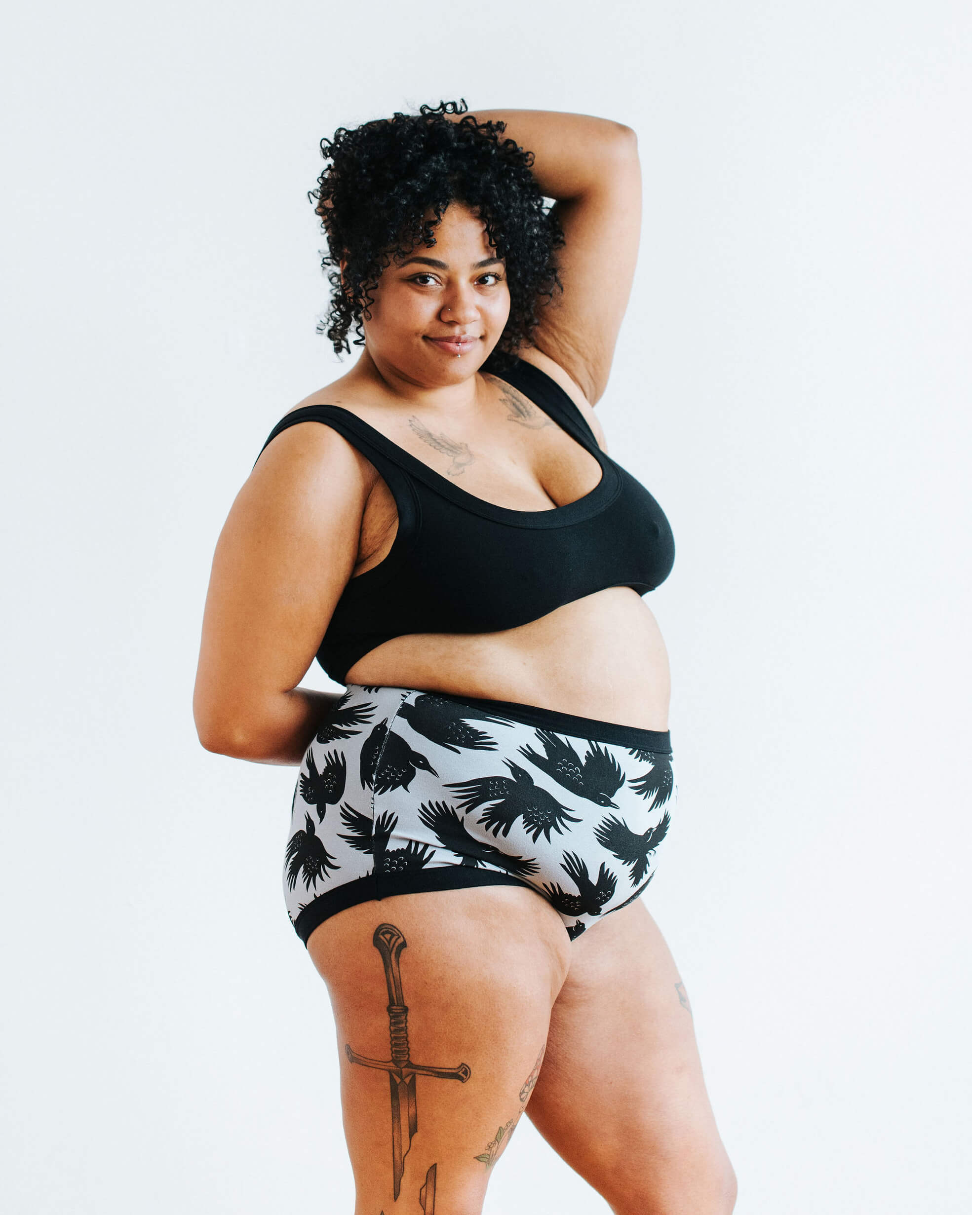 Model wearing Thunderpants Sky Rise style underwear in So it Crows - black crows in grey - and Plain Black Bralette.