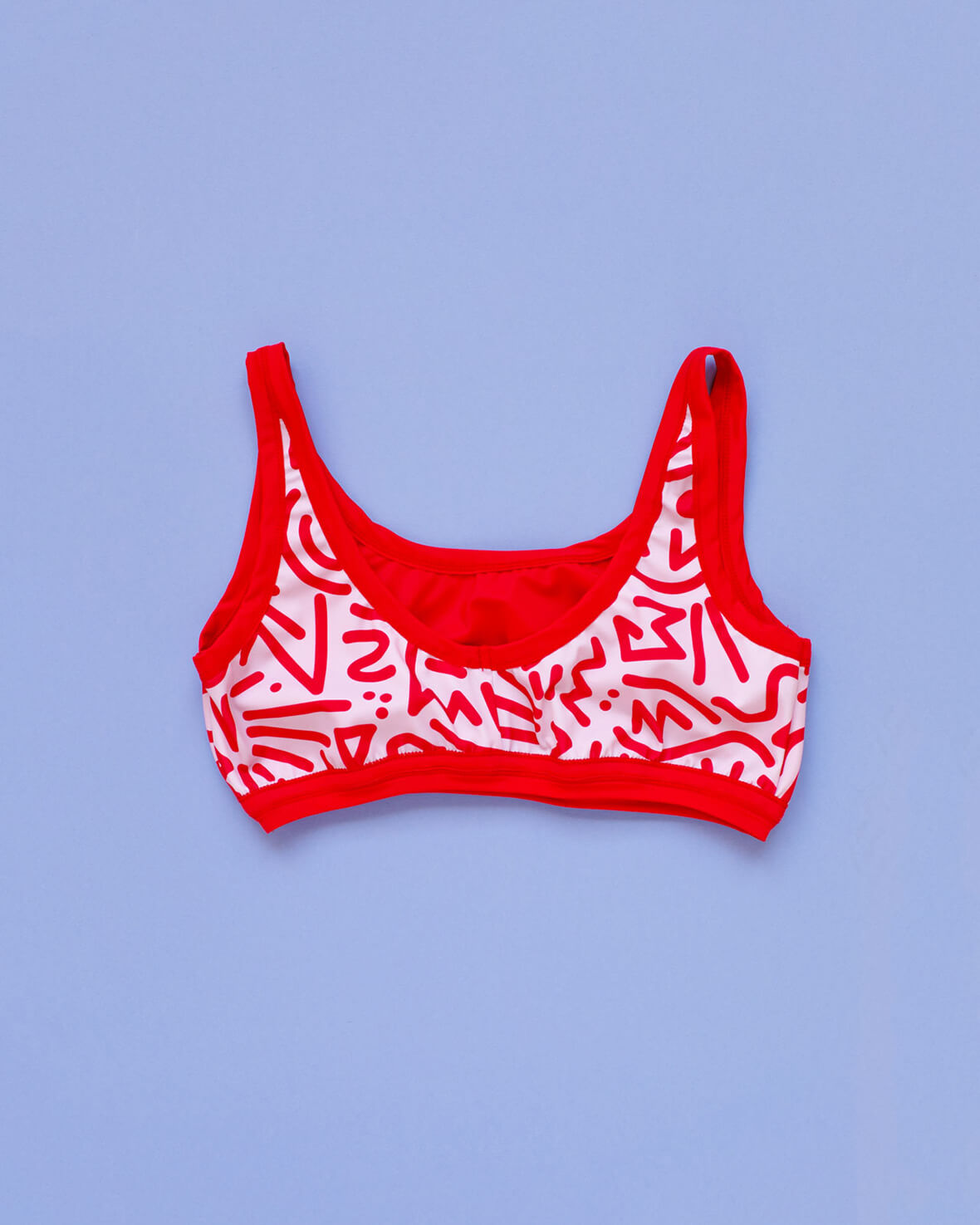 Flat lay of Thunderpants Swim Top in Energy Vibes print: light pink with dark pink designs.