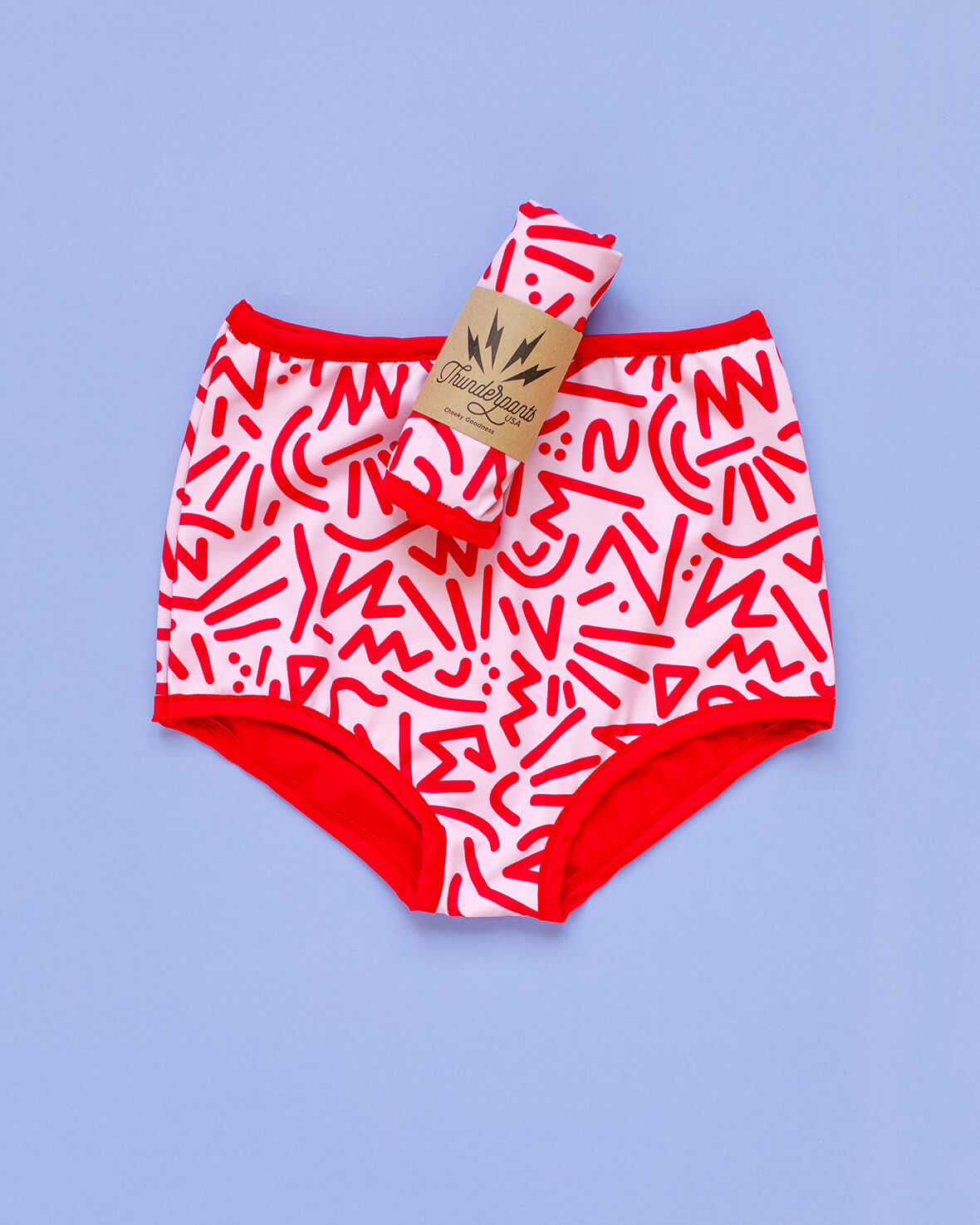 Flat lay of Thunderpants Sky Rise style Swim Bottoms in Energy Vibe print: light pink with dark pink designs.