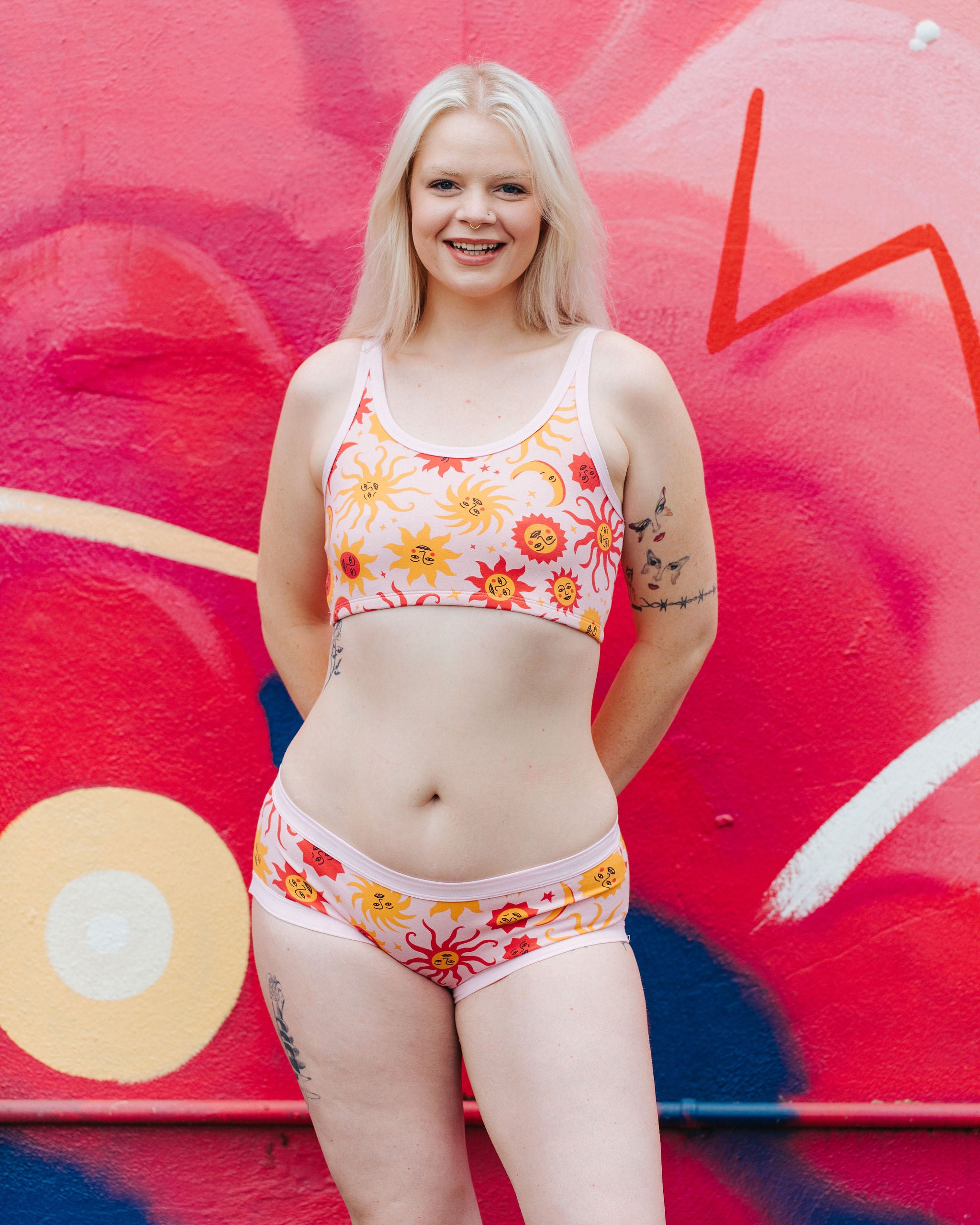Model wearing Thunderpants Hipster style underwear and Longline Bra in Luna y Sol print - pink, yellow, and orange suns and moons.