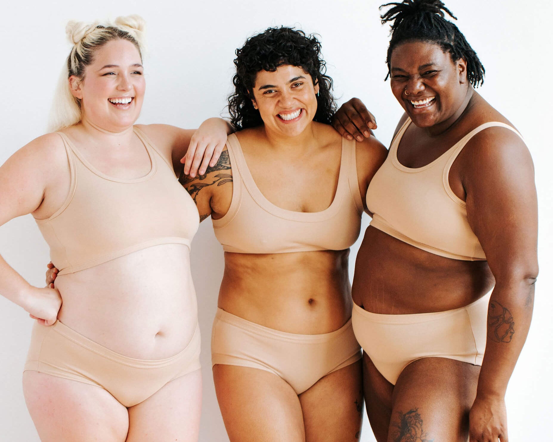Three models wearing Thunderpants Hipster styler underwear and Bras in Pine Nut - lighter tan color.