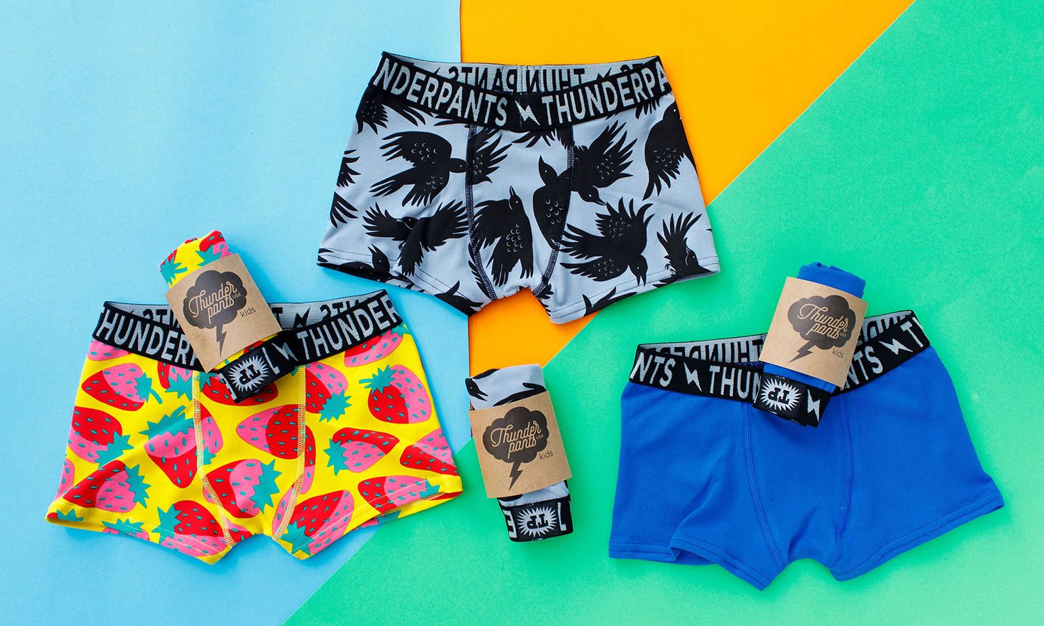 Flat lay of three Thunderpants Kids Boxer Brief style underwear in So it Crows, Strictly Strawberry, and Blueberry Blue.