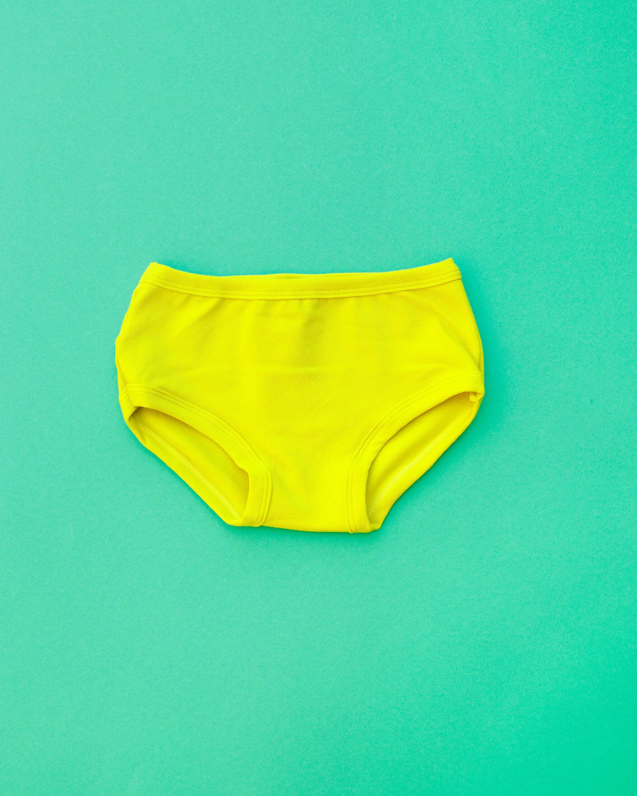 Flat lay of Thunderpants Kid's style underwear in Star Fruit - a yellow chartreuse color.