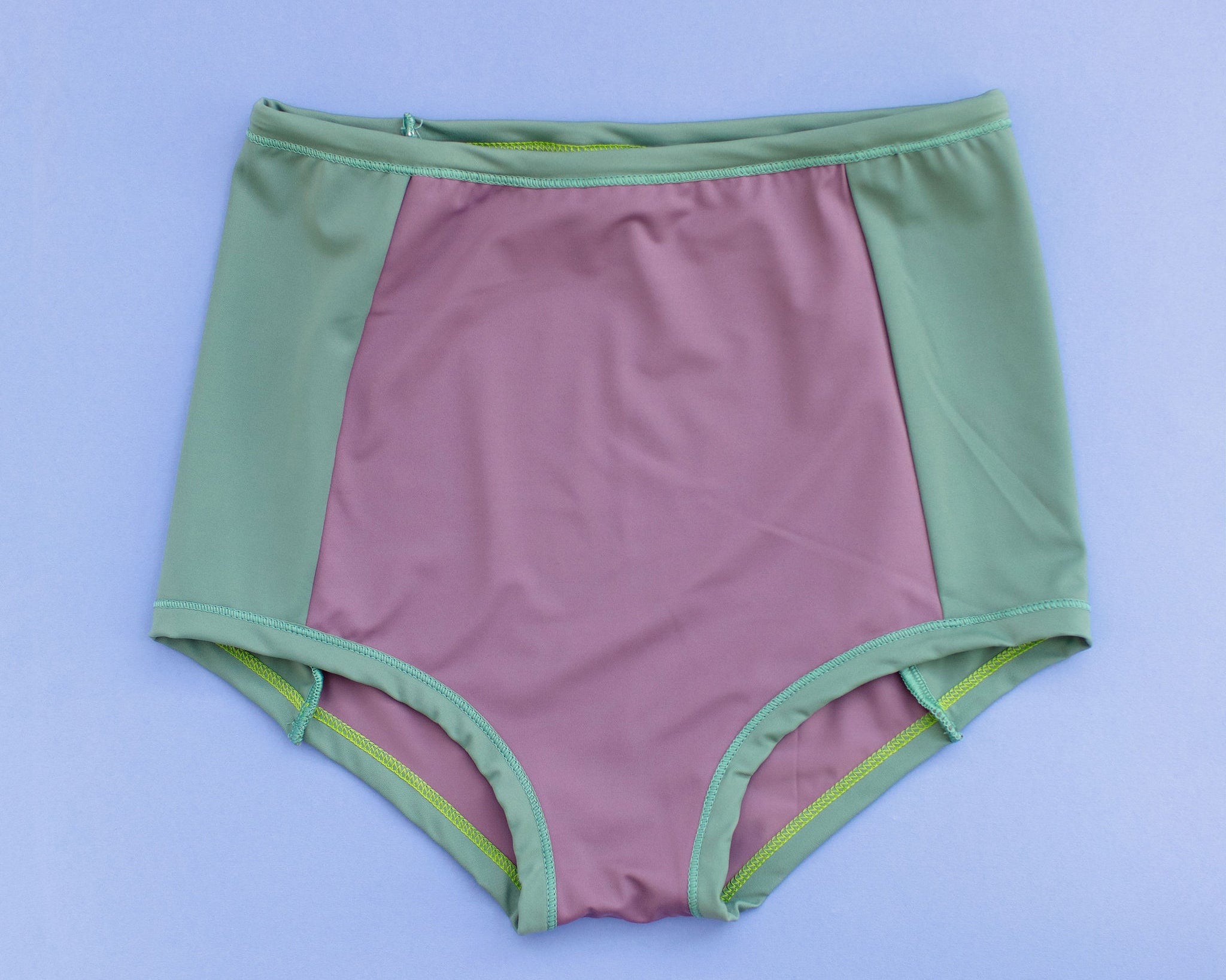Flat lay of Swimwear Sky Rise Panel Bottom in lavender and lichen green.