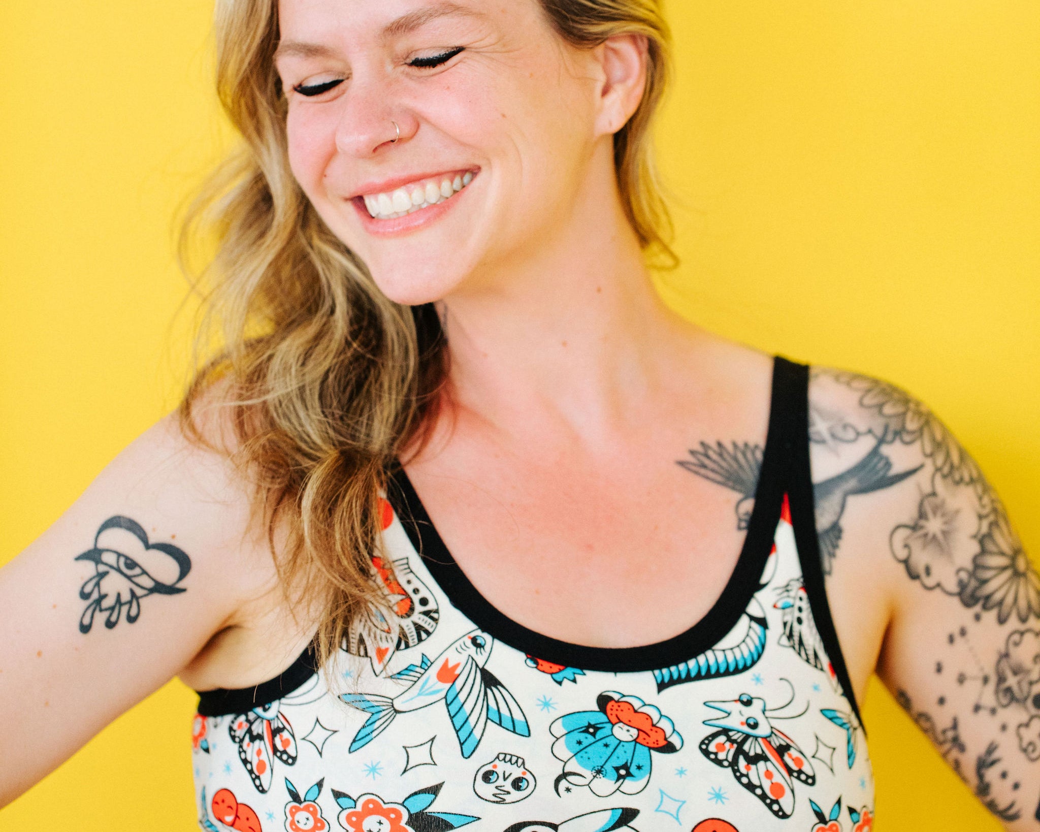 Model wearing Thunderpants Longline Bra in Inked Up - a tattoo pattern with black, red, and blue.
