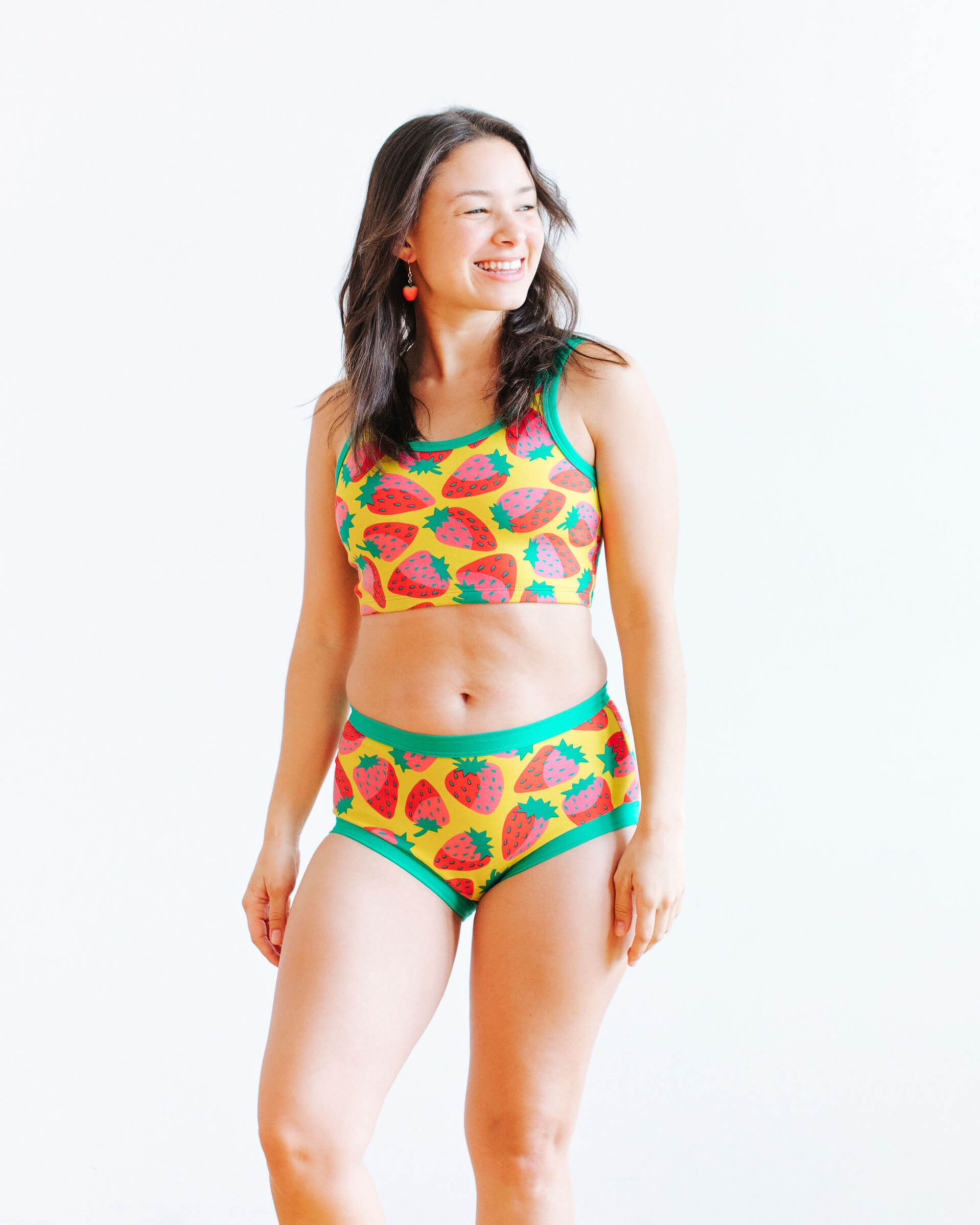 Model wearing Thunderpants Original style underwear and Longline Bra in a Strawberry print - pink, red, and peacock green on chartreuse.