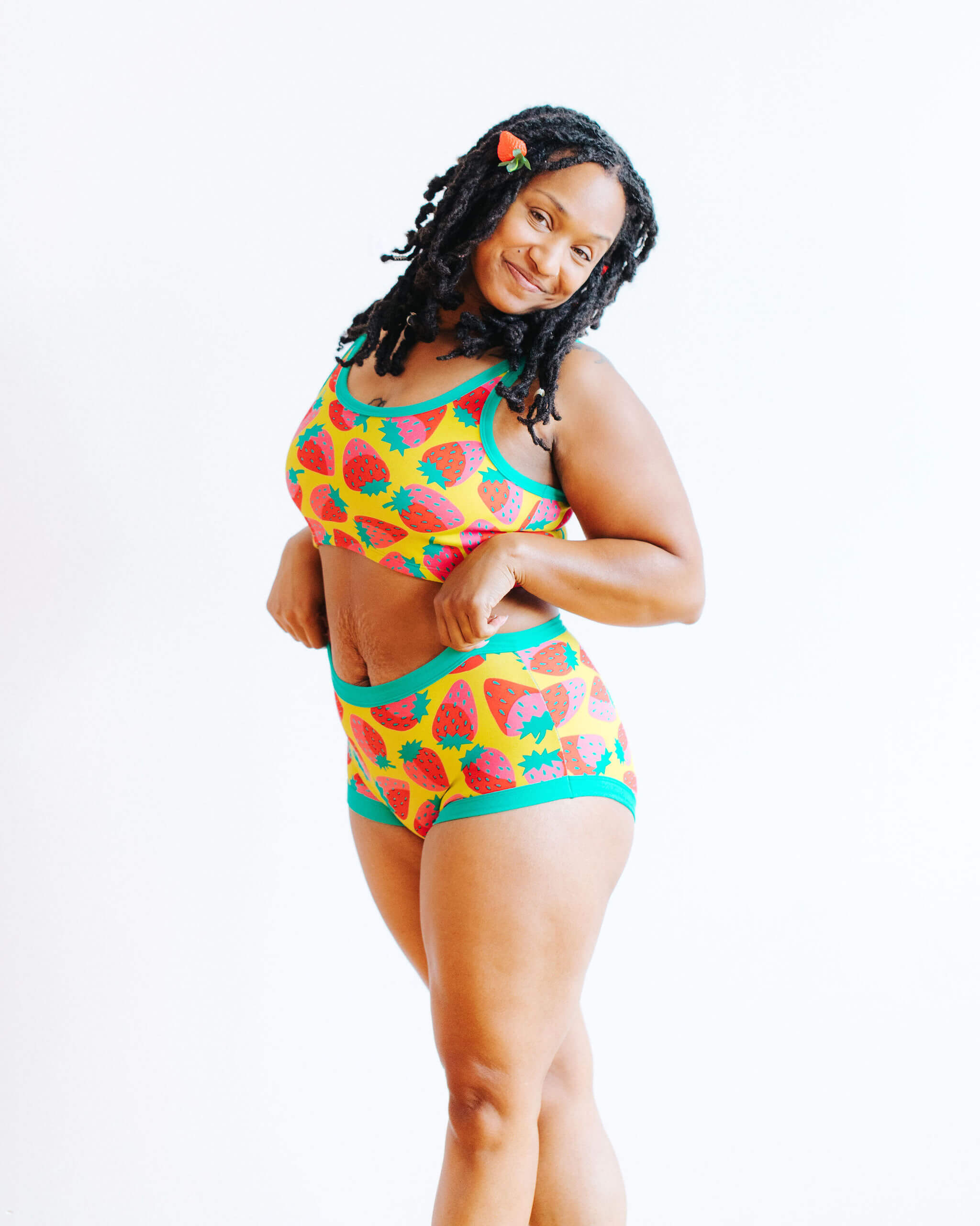 Model wearing Thunderpants Original style underwear and Longline Bra in a Strawberry print - pink, red, and peacock green on chartreuse.