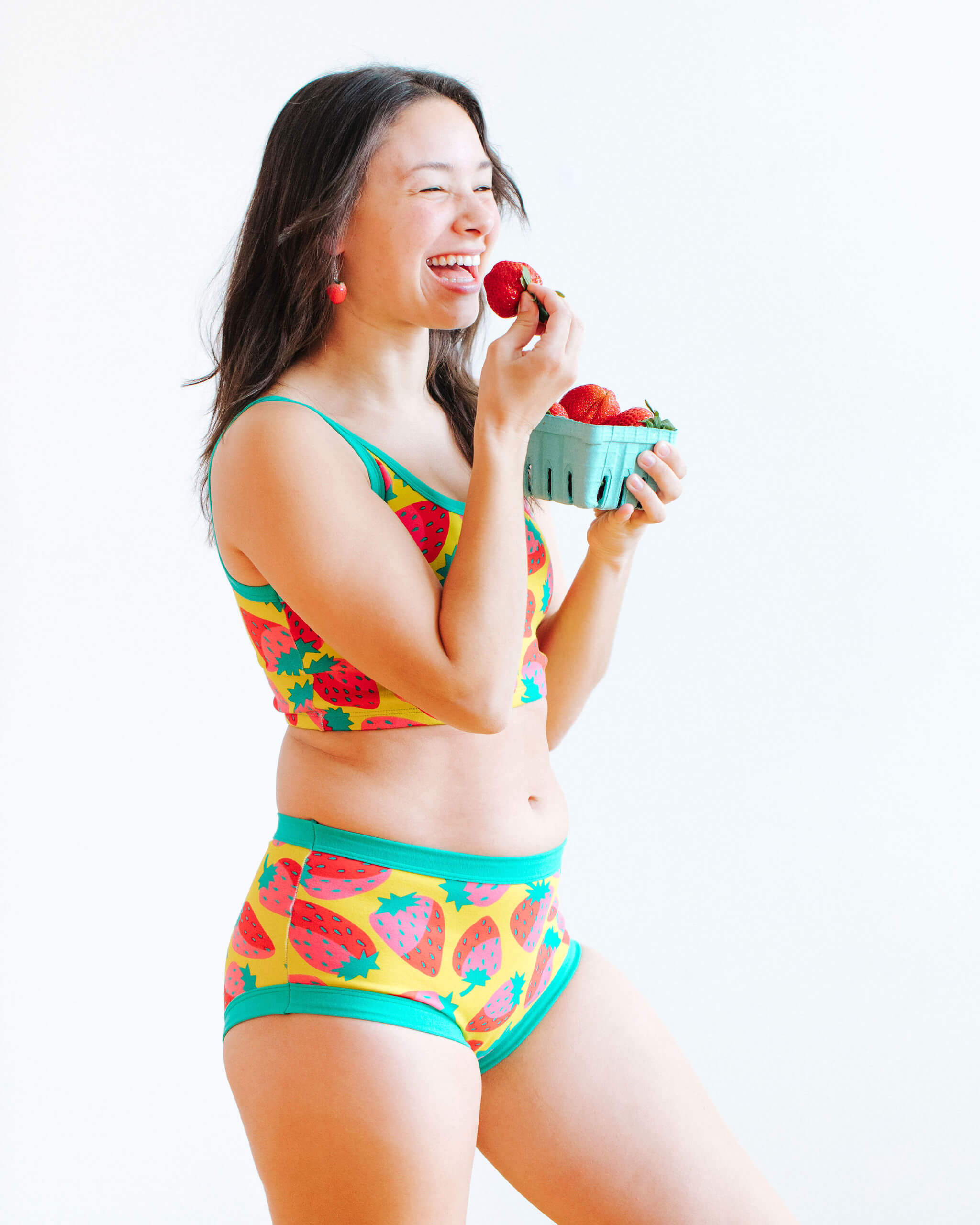 Model wearing Thunderpants Original style underwear and Longline Bra in a Strawberry print - pink, red, and peacock green on chartreuse.