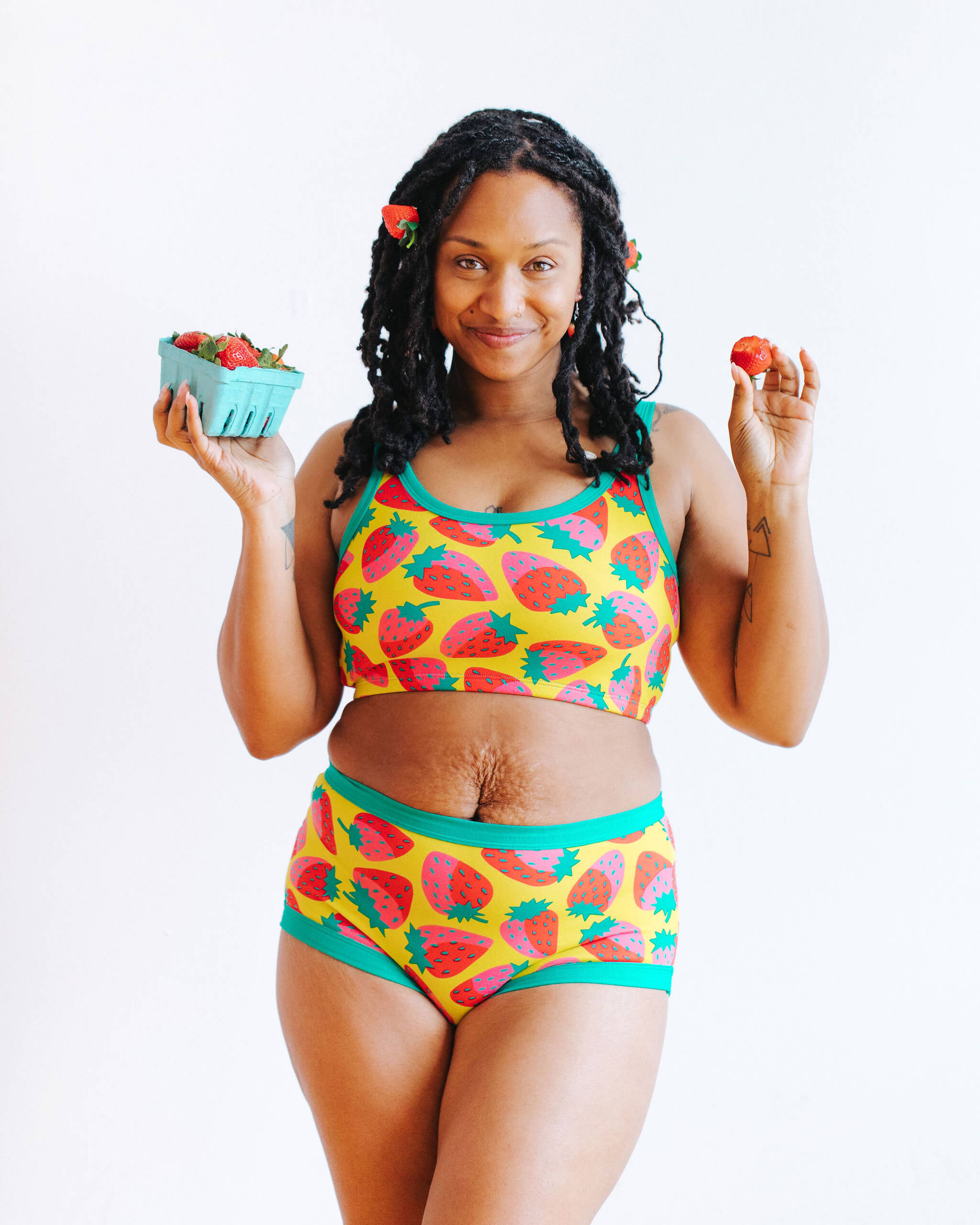 Model wearing Thunderpants Original style underwear and Longline Bra in a Strawberry print - pink, red, and peacock green on chartreuse.