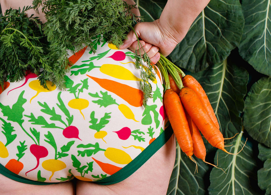 Close up of models bum wearing Thunderpants Original style underwear in Root Veggies print: pink, yellow, orange, and green.