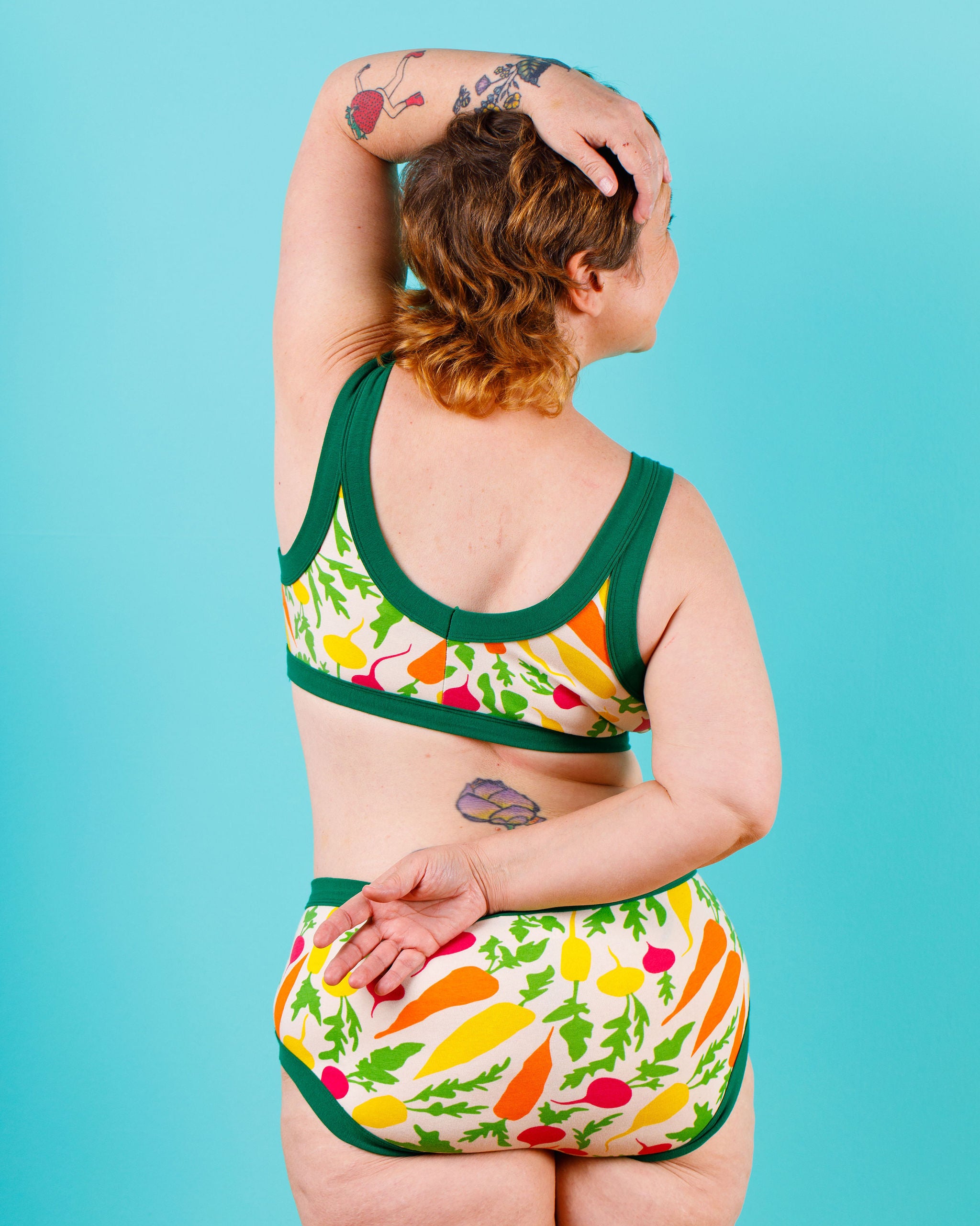 Back of model wearing Thunderants Hipster style underwear and matching Bralette in Root Veggies print - yellow, orange, pink, and green vegetables.