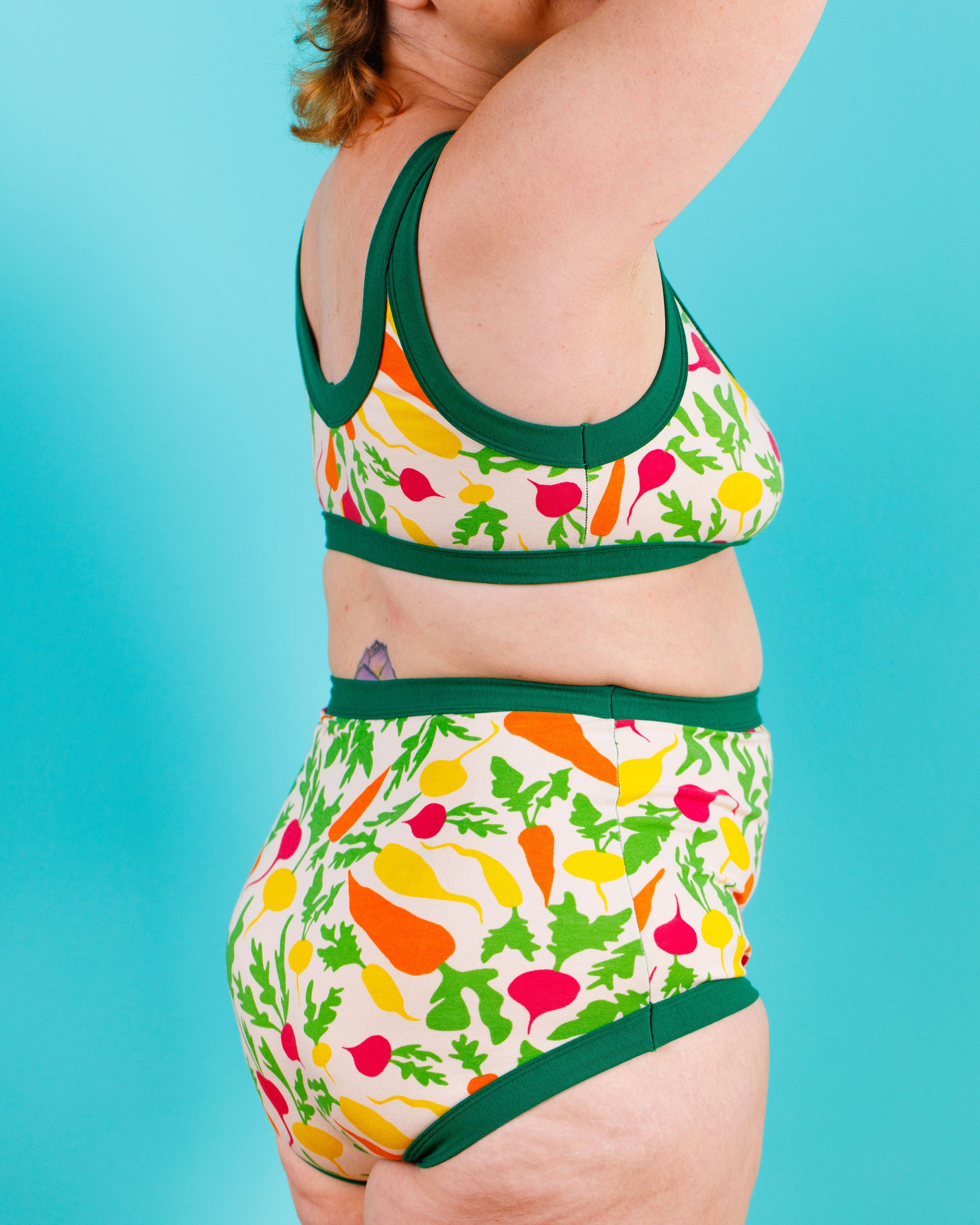 Model wearing Thunderants Sky Rise style underwear and matching Bralette in Root Veggies print - yellow, orange, pink, and green vegetables.