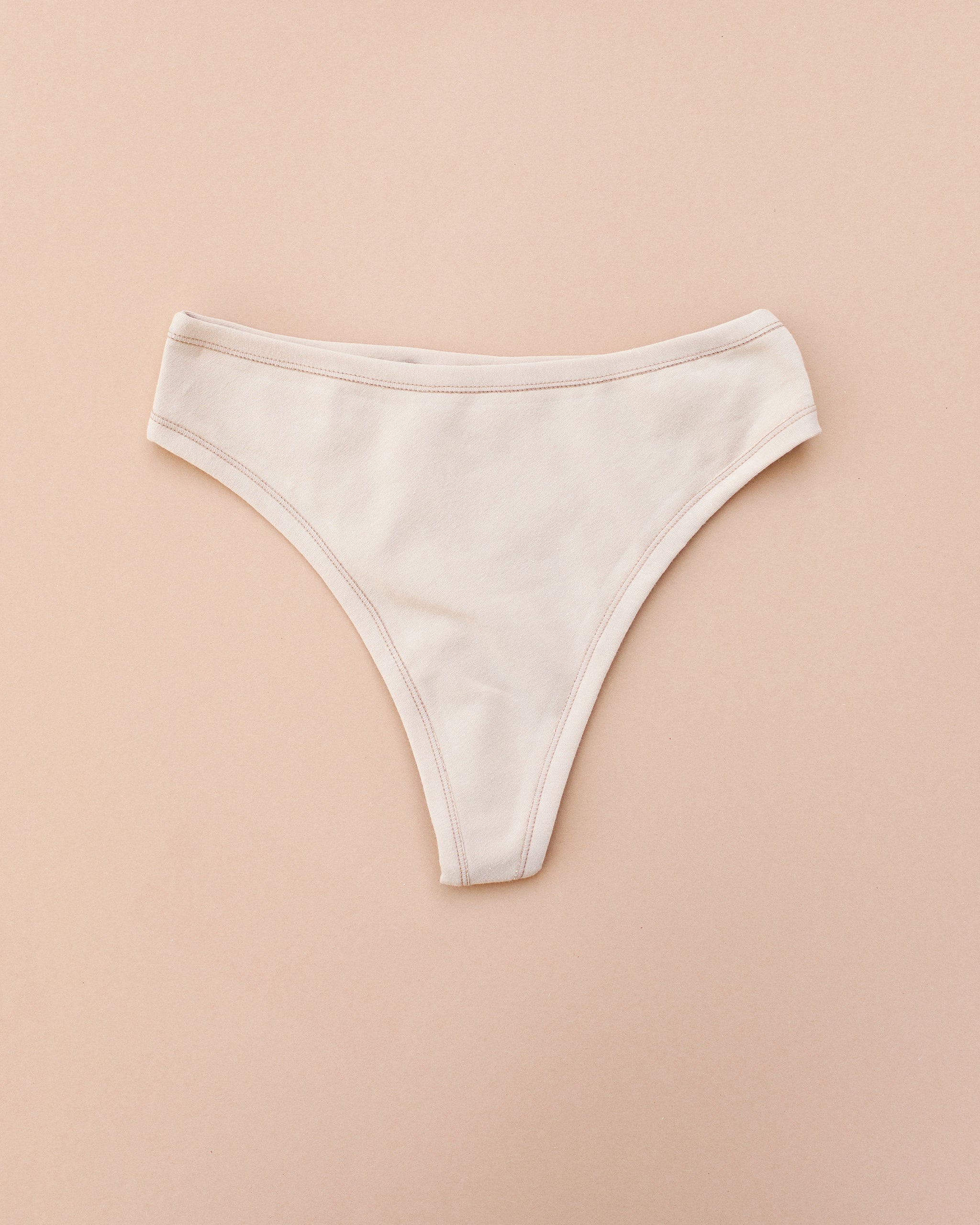 Flay lay of Thunderpants Thong style underwear in Pine Nut - a tan color.