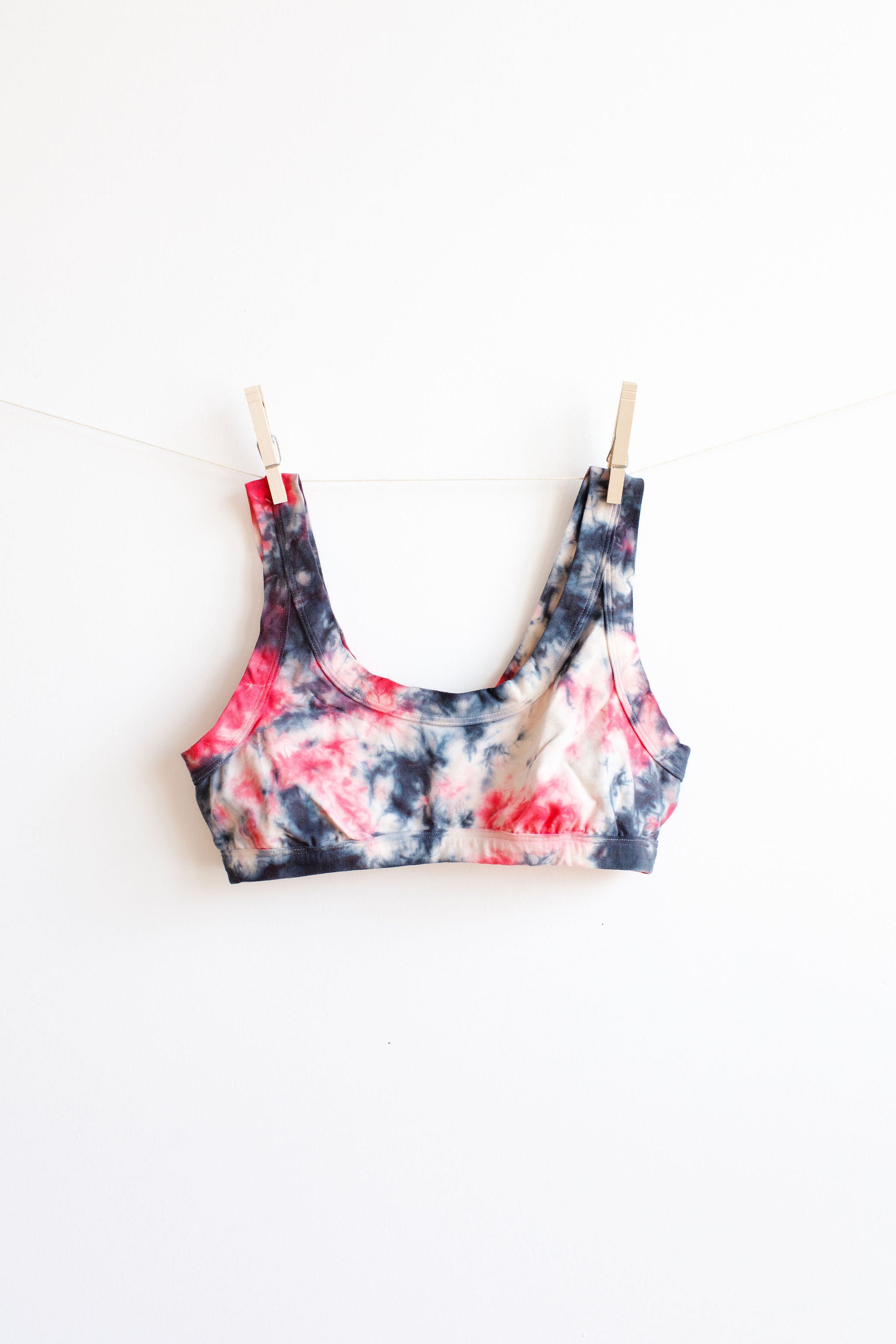 Hanging Thunderpants Bralette with black, red, and white scrunch dye on a white background.