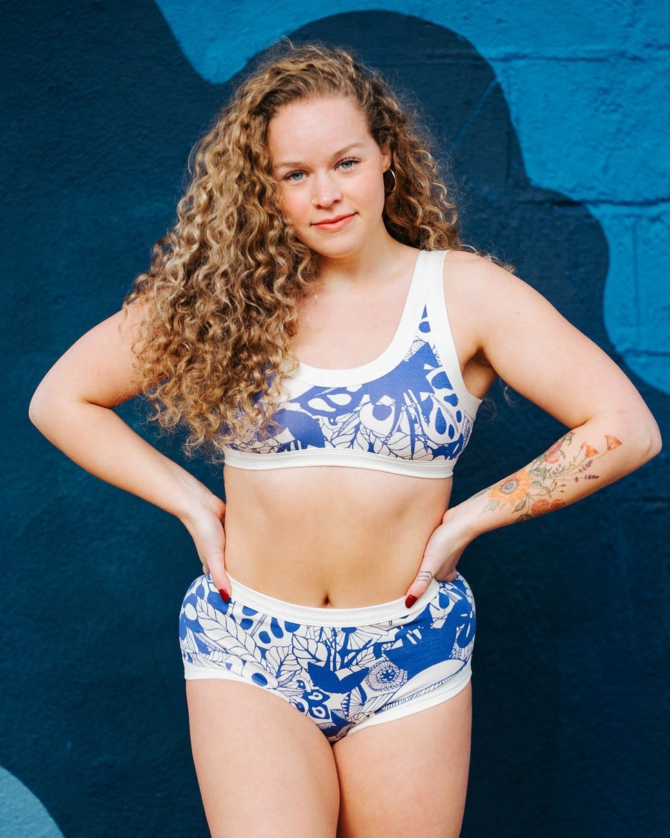 Woman wearing Thunderpants organic cotton Bra and Women's Original style underwear in a blue jungle and floral print.