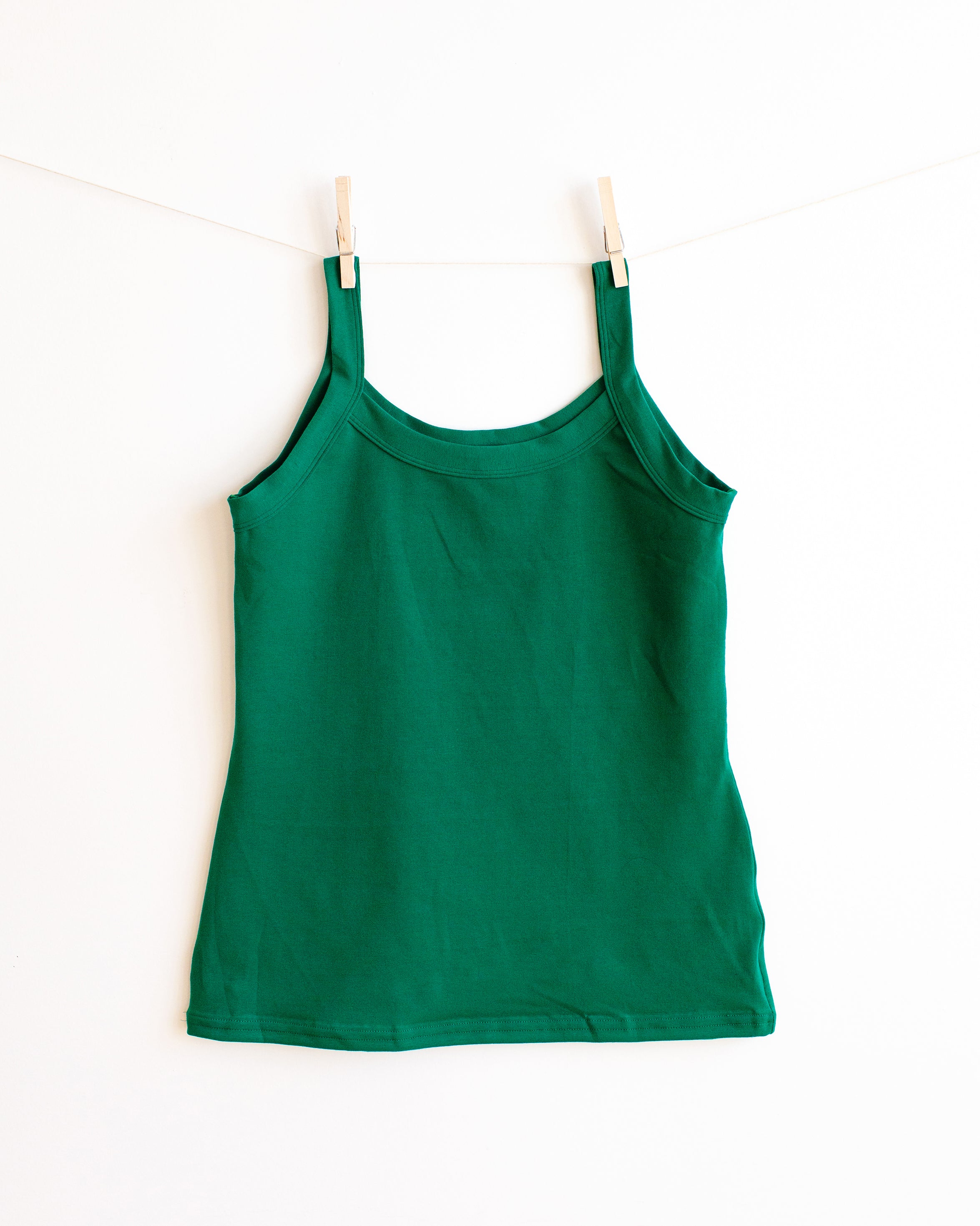 Thunderpants Camisole in Emerald Green hanging by clothes pins on a white wall.