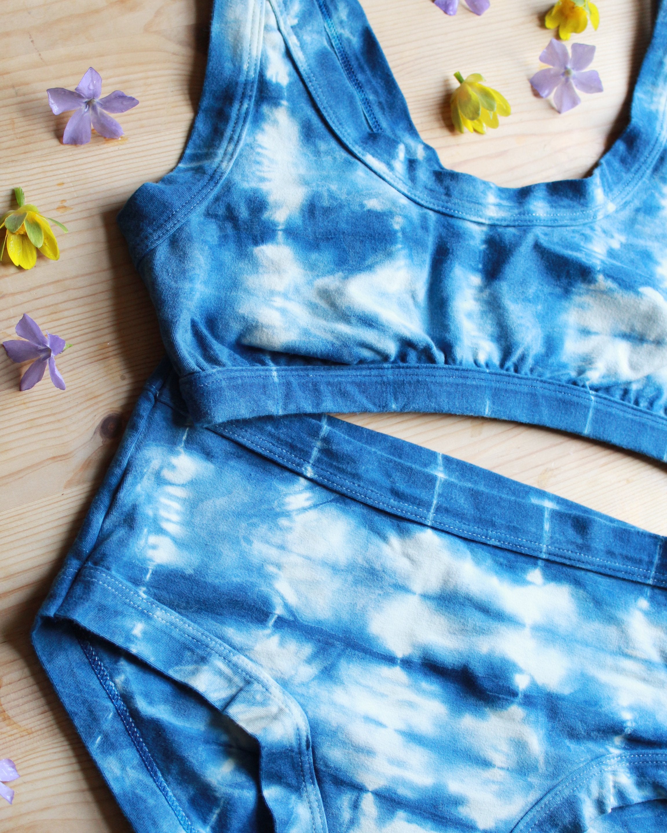 Close-up flat-lay of Thunderpants organic cotton Bralette and Hipster style underwear in shibori hand dyed indigo.