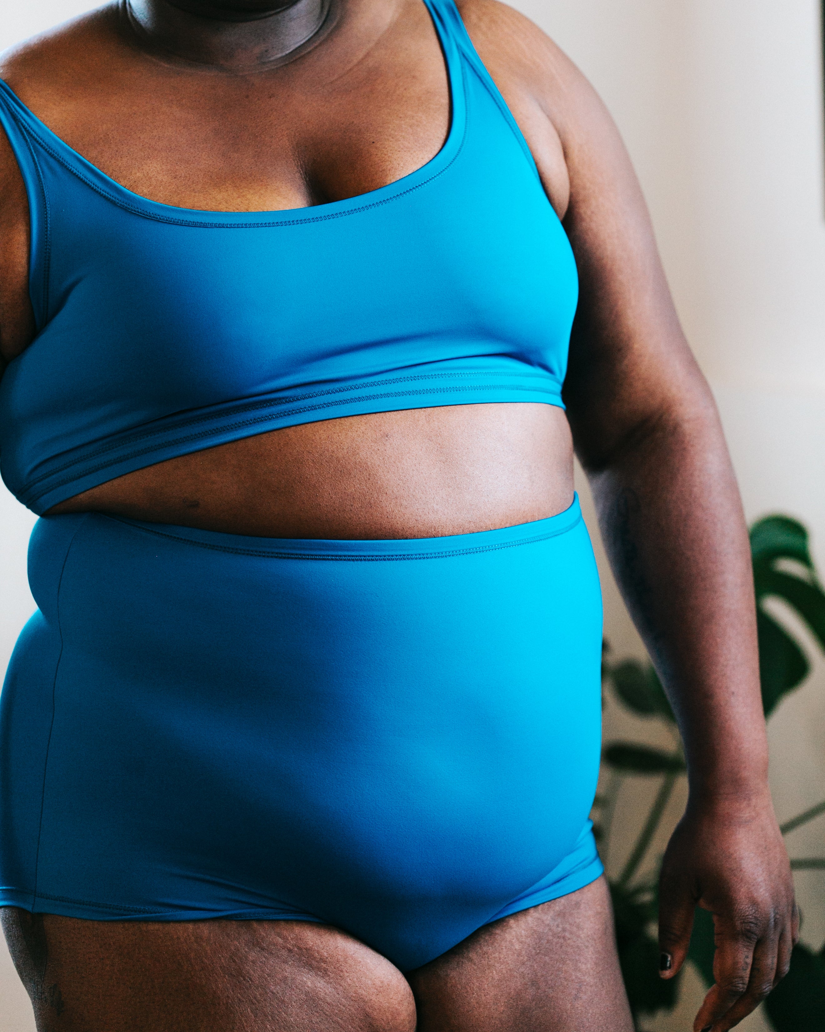 Close up of model wearing a Swimwear set of Sky Rise style bottoms and Top in Marina Blue.