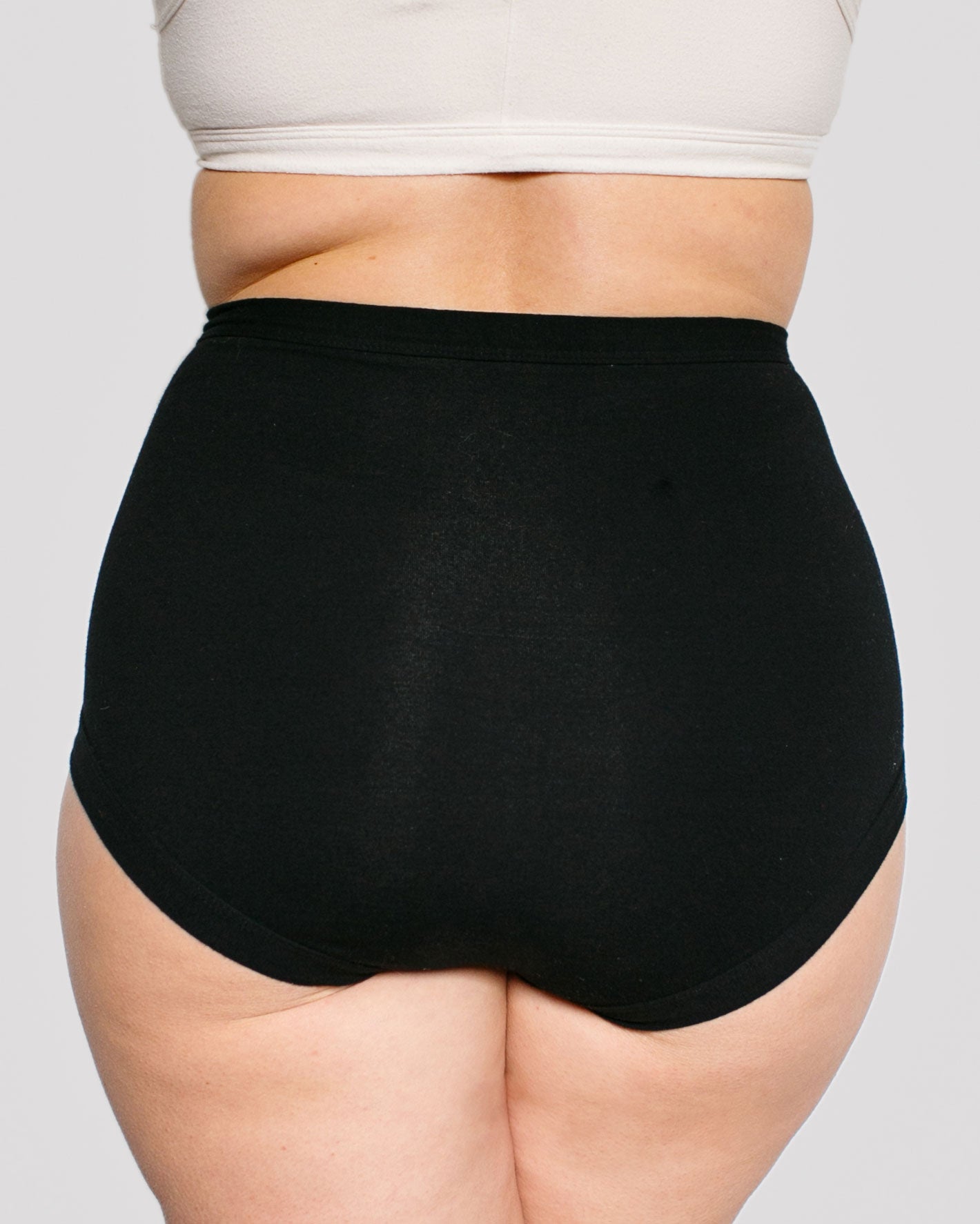 Fit photo from the back of Thunderpants organic cotton Sky Rise style underwear in Plain Black, showing a wedgie-free bum, on a model.
