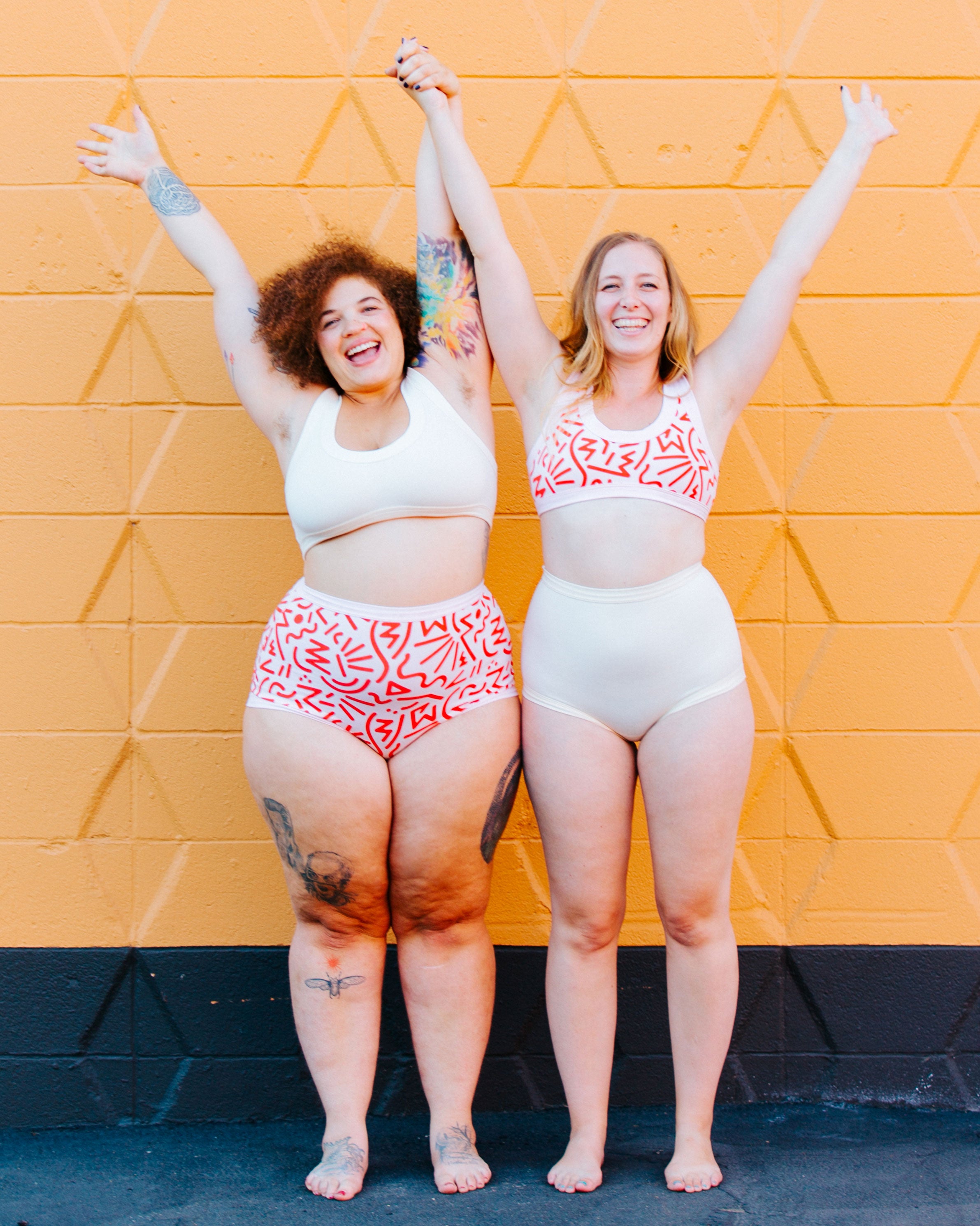 Two models standing together smiling wearing Thunderpants organic cotton Sky Rise style underwear and Bralettes in both Plain Vanilla and our Energy Vibes print.