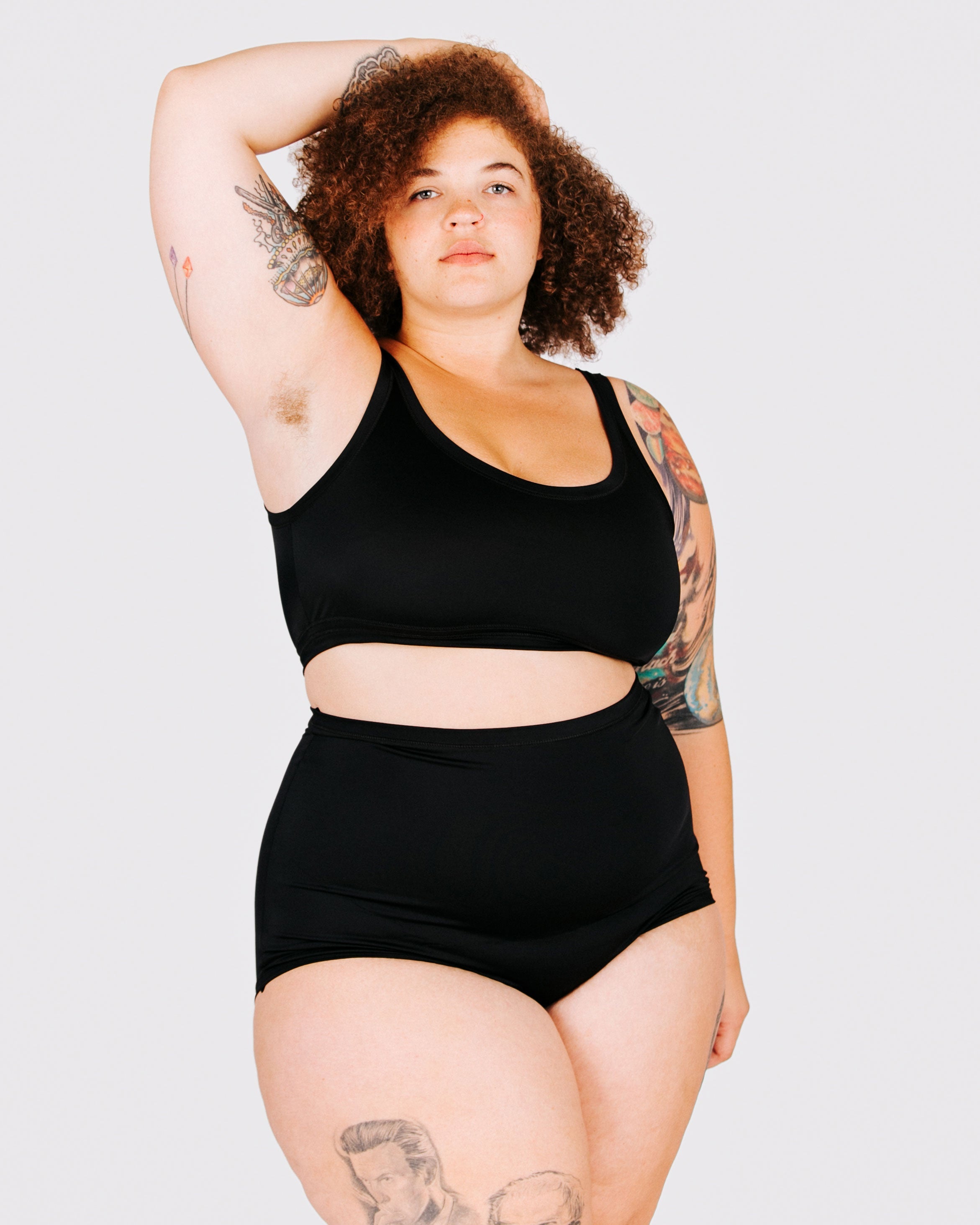 Fit photo from the front of Thunderpants recycled nylon Swimwear Sky Rise style bottoms in Plain Black on a model.