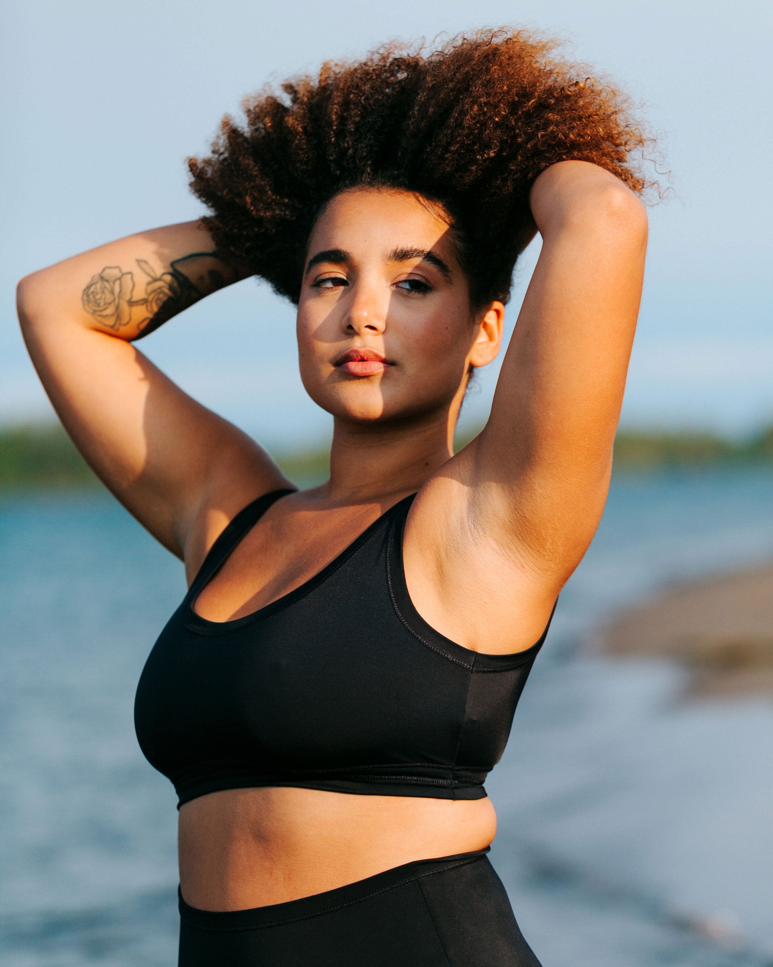 Close up of model wearing Thunderpants recycled nylon Swimwear Top in Plain Black.