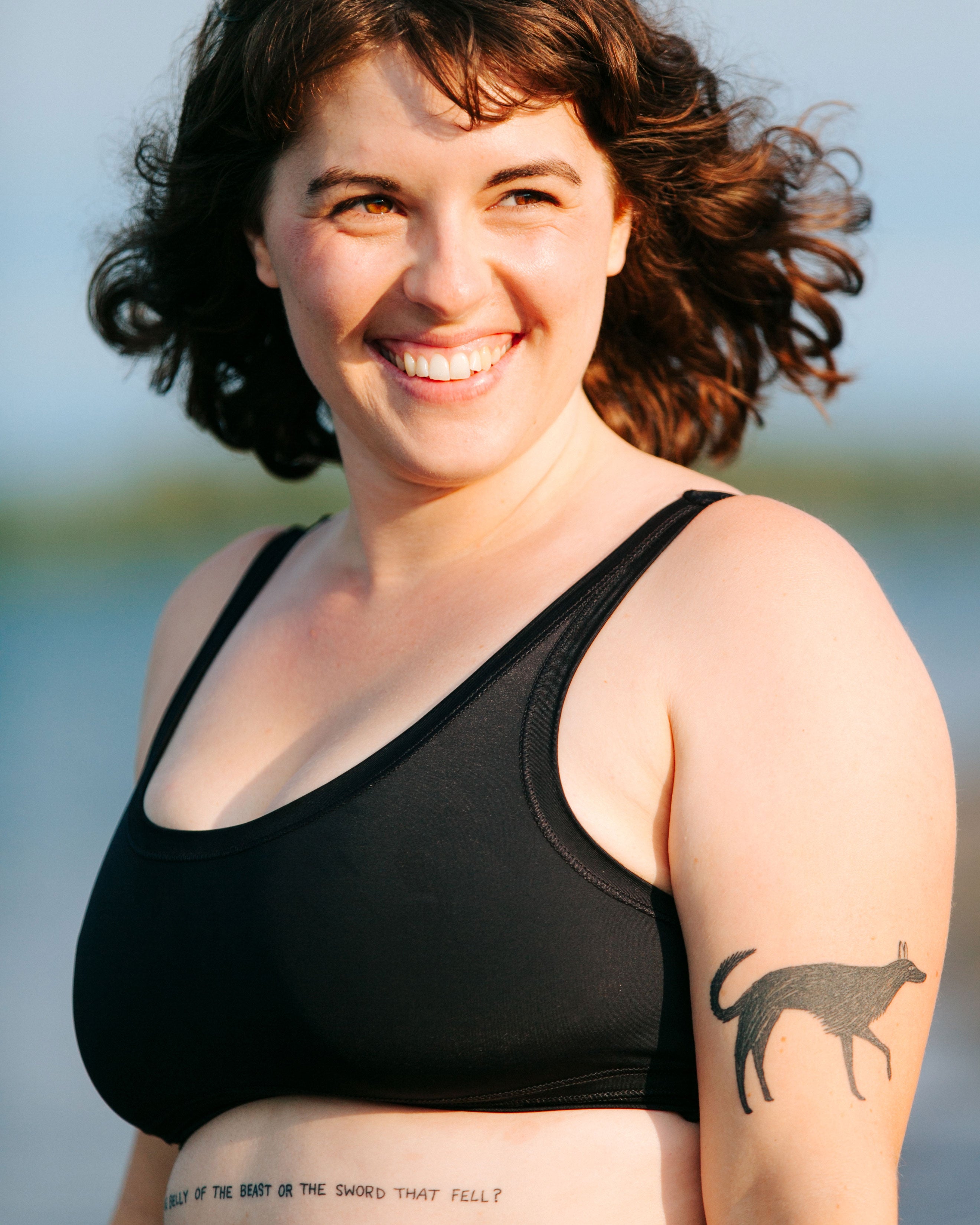 Close-up of model wearing Thunderpants recycled nylon Swimwear Top in Plain Black.