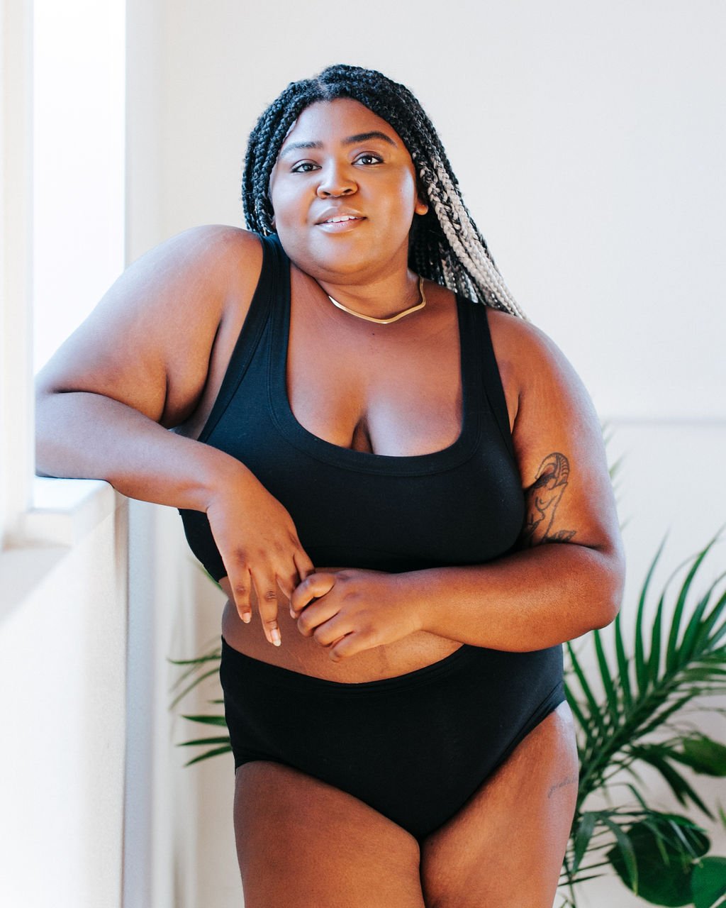 Beautiful plus-sized model wearing Thunderpants organic cotton Bralette and Hipster style underwear in plain black.