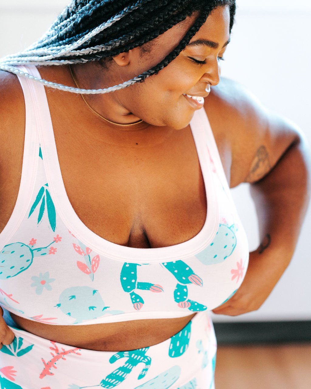 Close-up photo of a plus-sized woman wearing Thunderpants organic cotton Bralette in a pink and green cactus print.