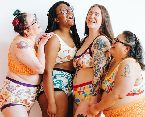 Four models laughing together wearing a variety of prints and styles.