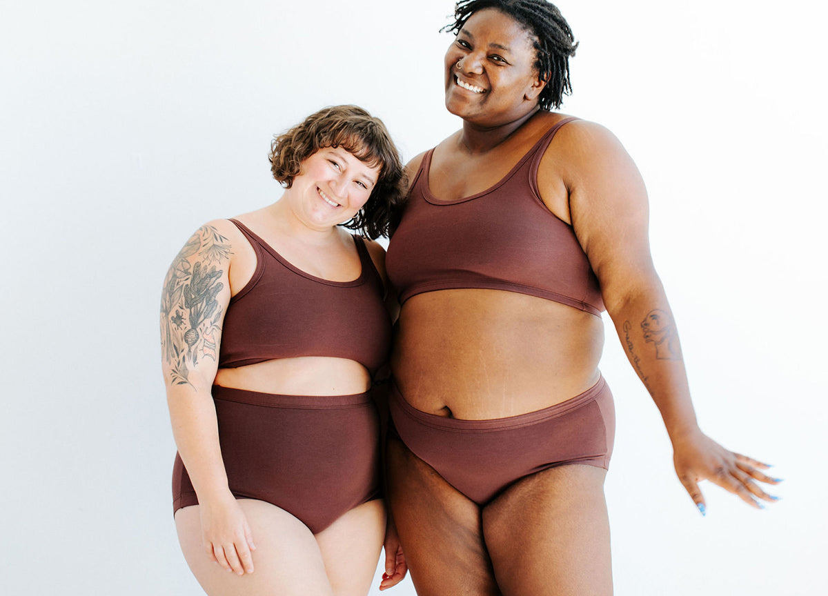 Two models smiling in various Thunderpants items in Chestnut - a dark brown color.