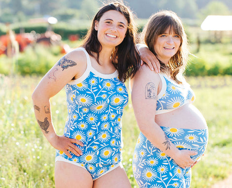 Two models smiling on a farm in various Thunderpants styles of Daisy Days print.