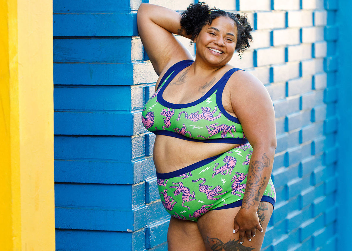 Model wearing an organic cotton Thunderpants set in Electric Tiger print - green with pink tigers and blue binding.